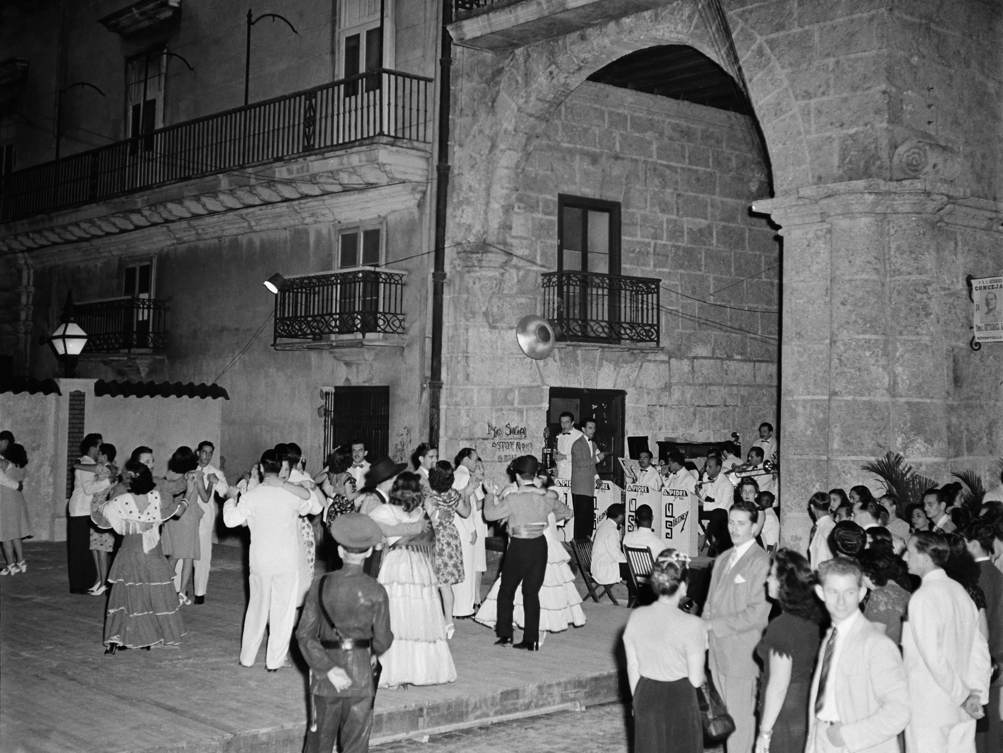 HAVANA, CUBA - JANUARY 1946: People dance in traditional costumes at the Havana Cathedral in Havana, Cuba.