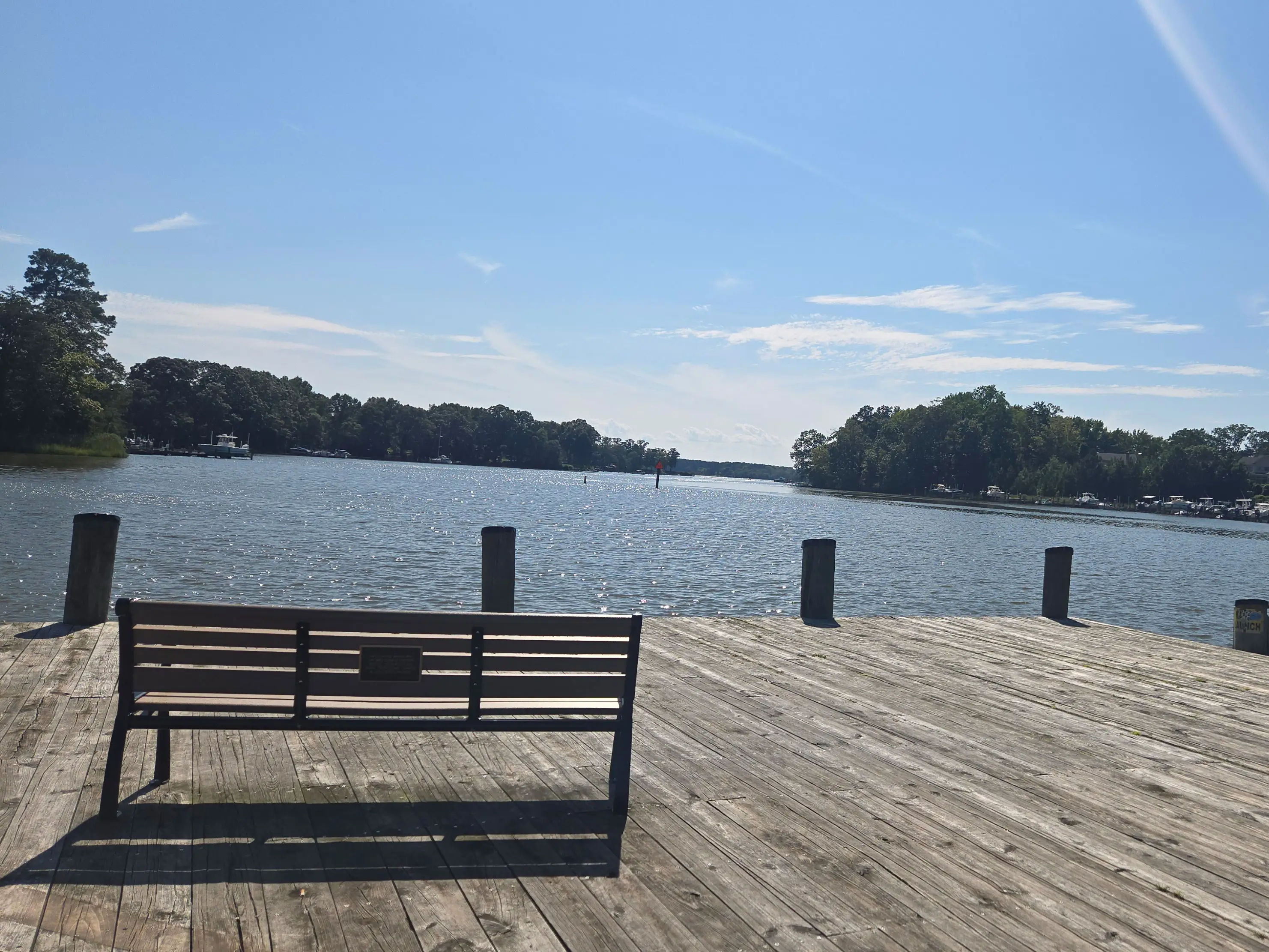A bench on a dock overlooking a river.