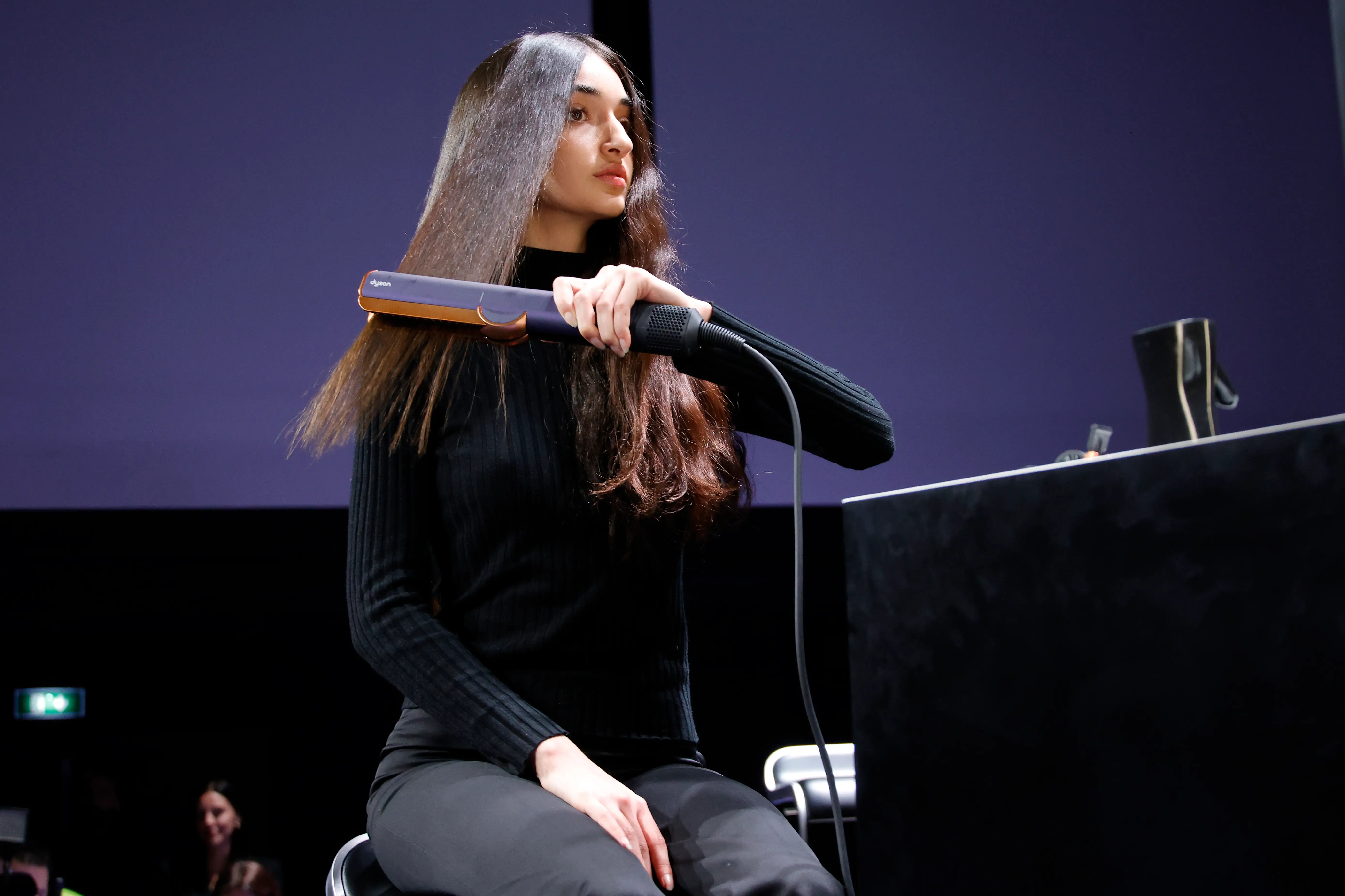 A model uses a Dyson hair straightener during a demonstration.