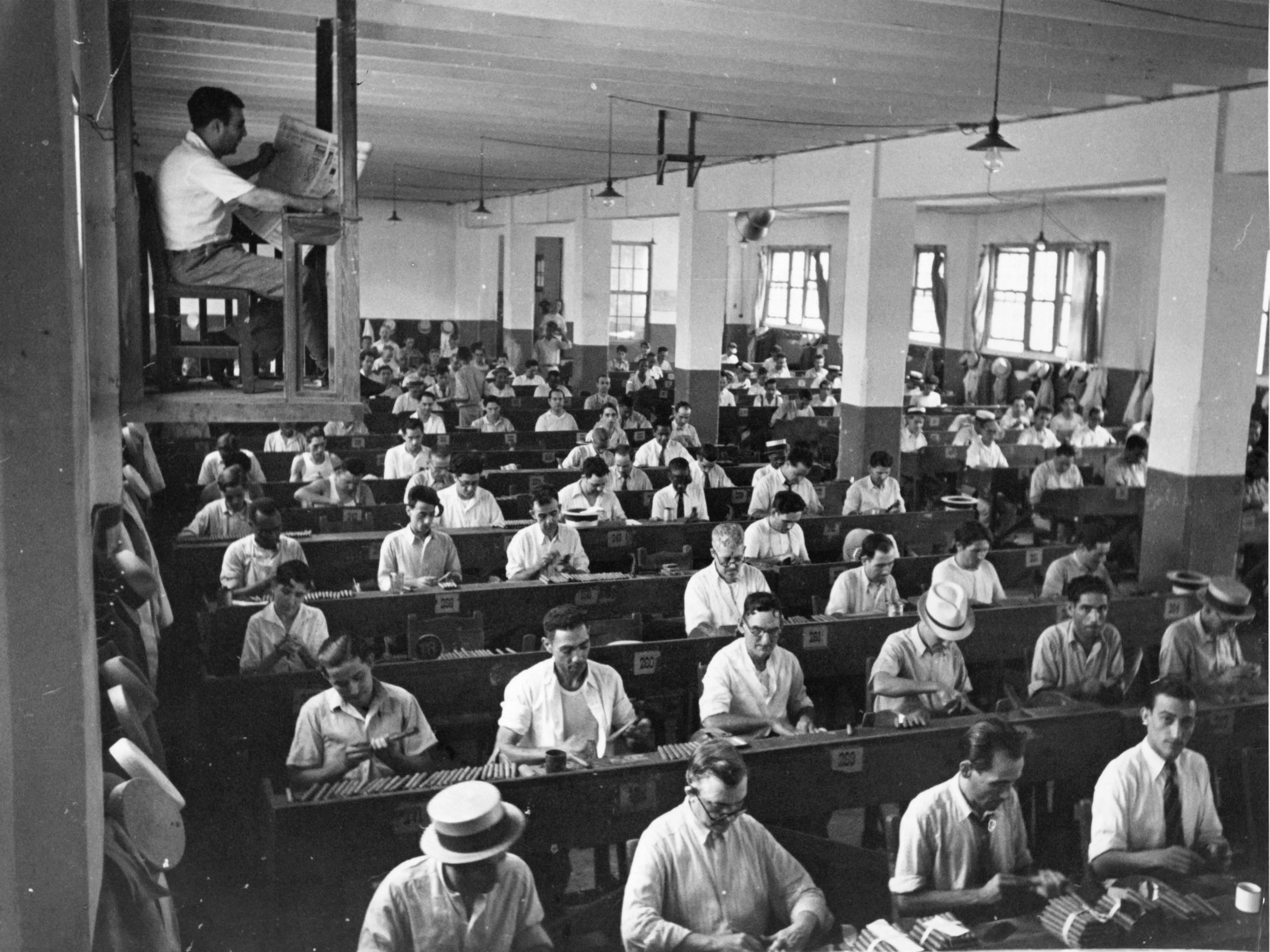 Men work in rows of benches at a cigar factory in Havana,Cuba. 1950