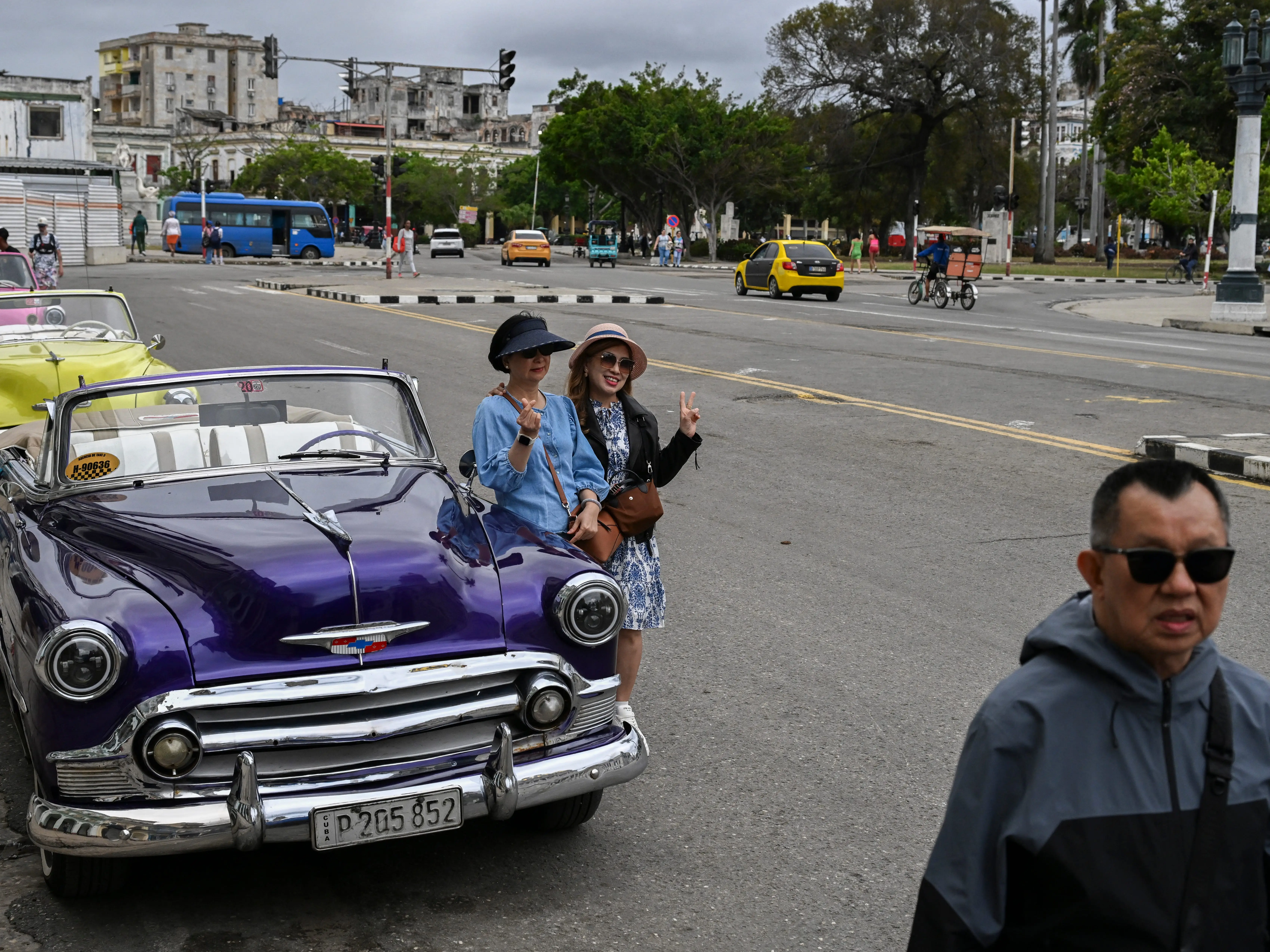 Tourists pose for photos with an American classic car in Havana on March 18, 2026.