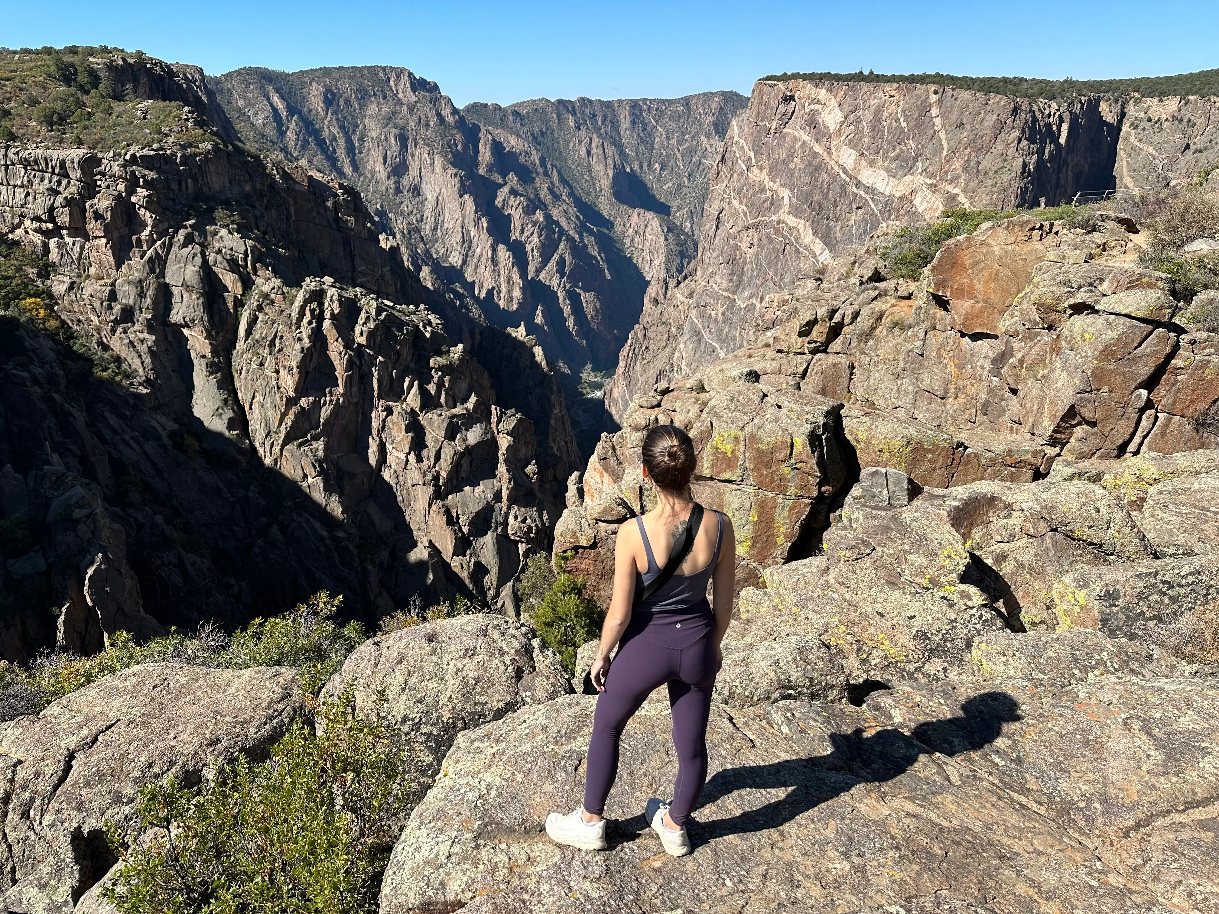 Woman in workout clothes staring at rock formations