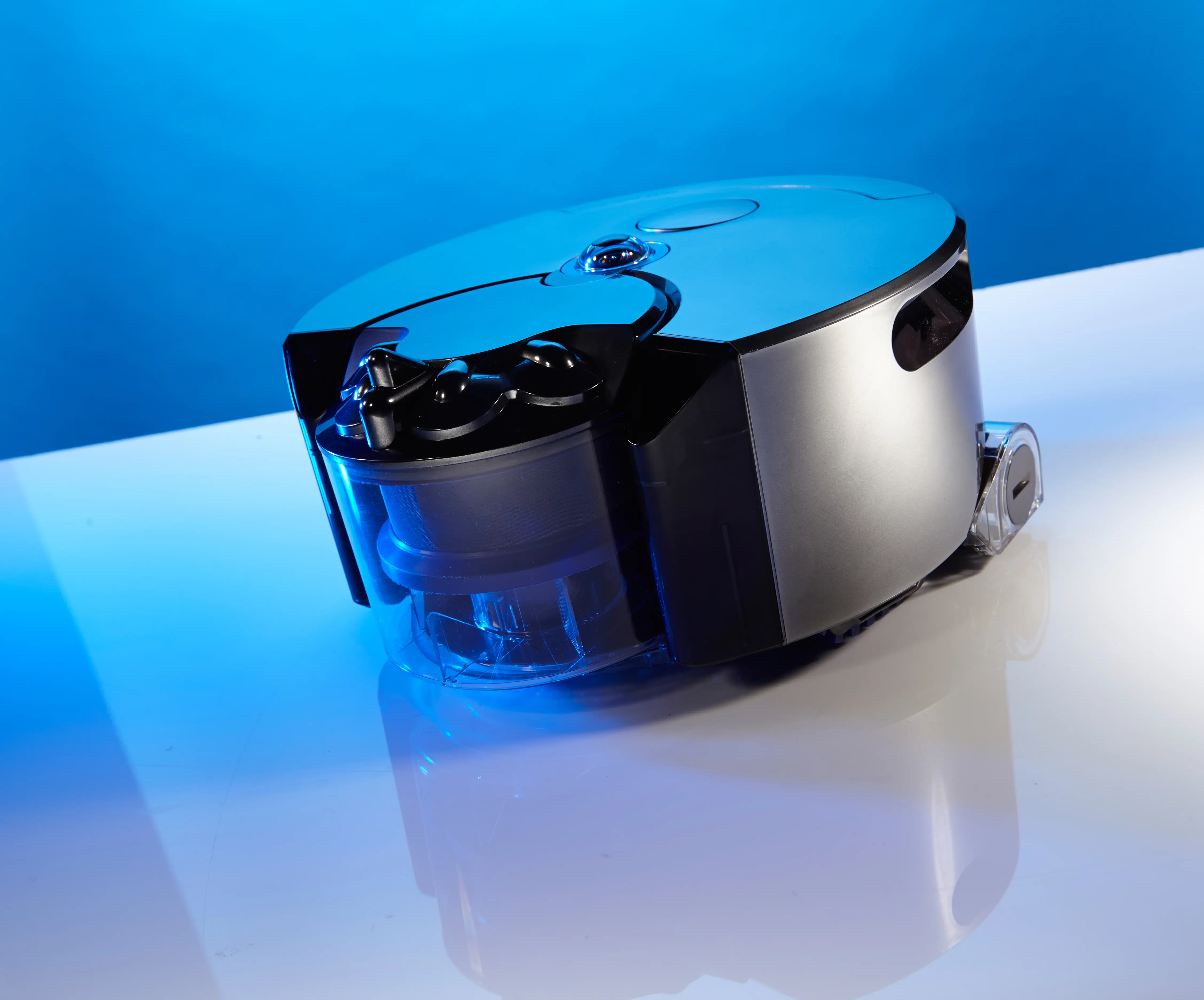 A Dyson robotics vacuum rests on a white floor.