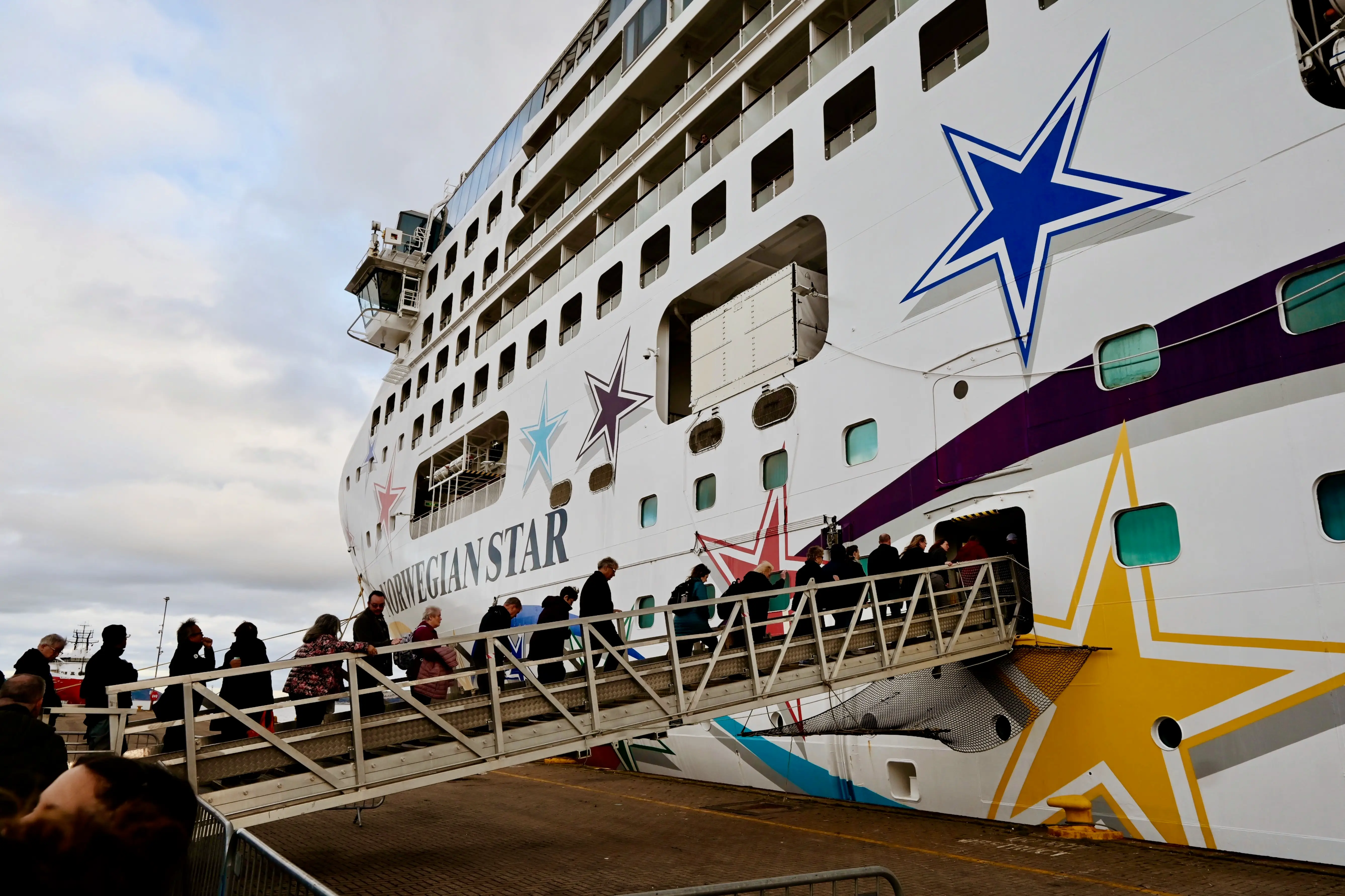 People walking onto Norwegian Star cruise ship via gangway