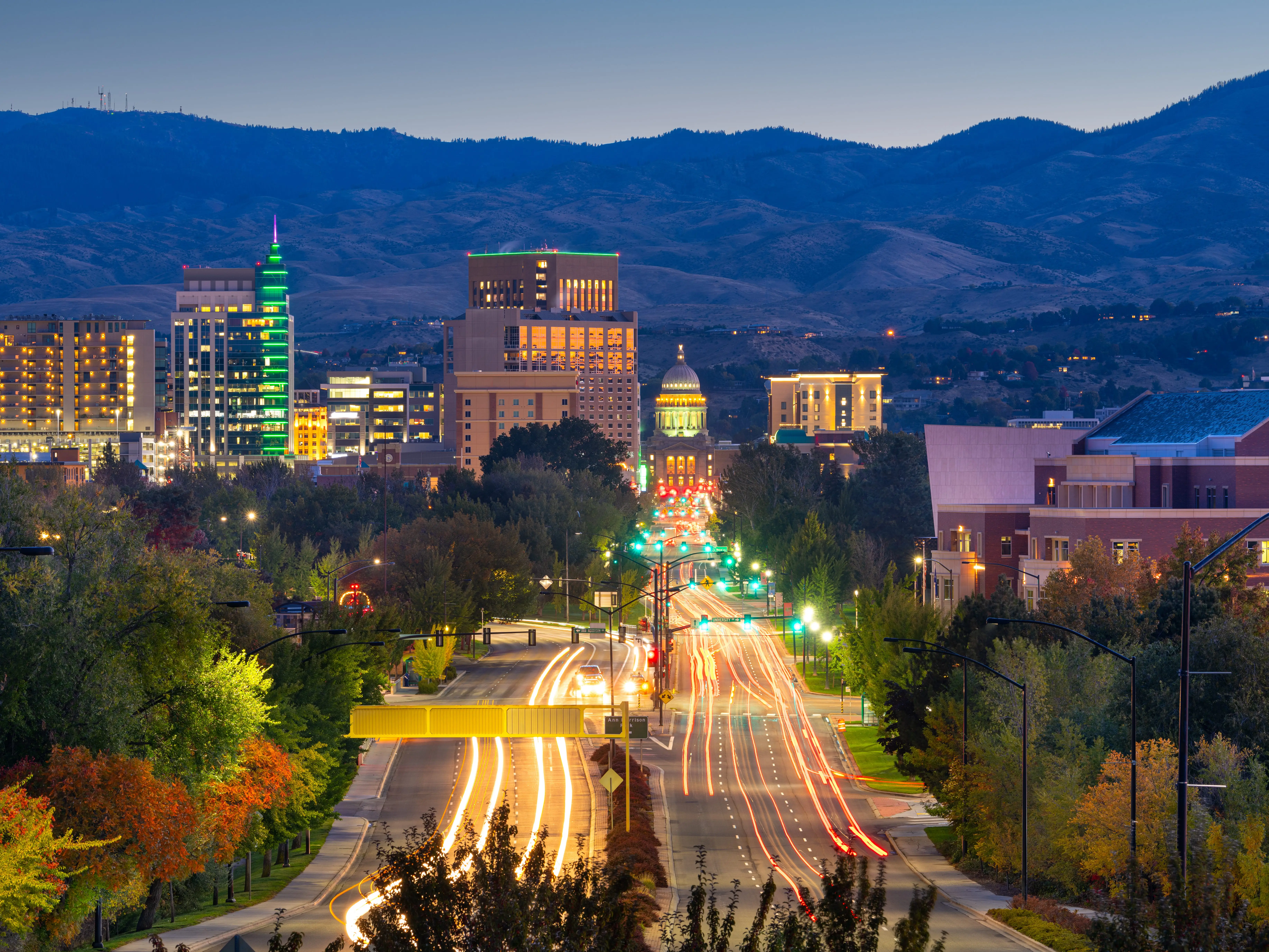 Downtown Boise skyline at dusk with light trails leading toward the Idaho State Capitol.