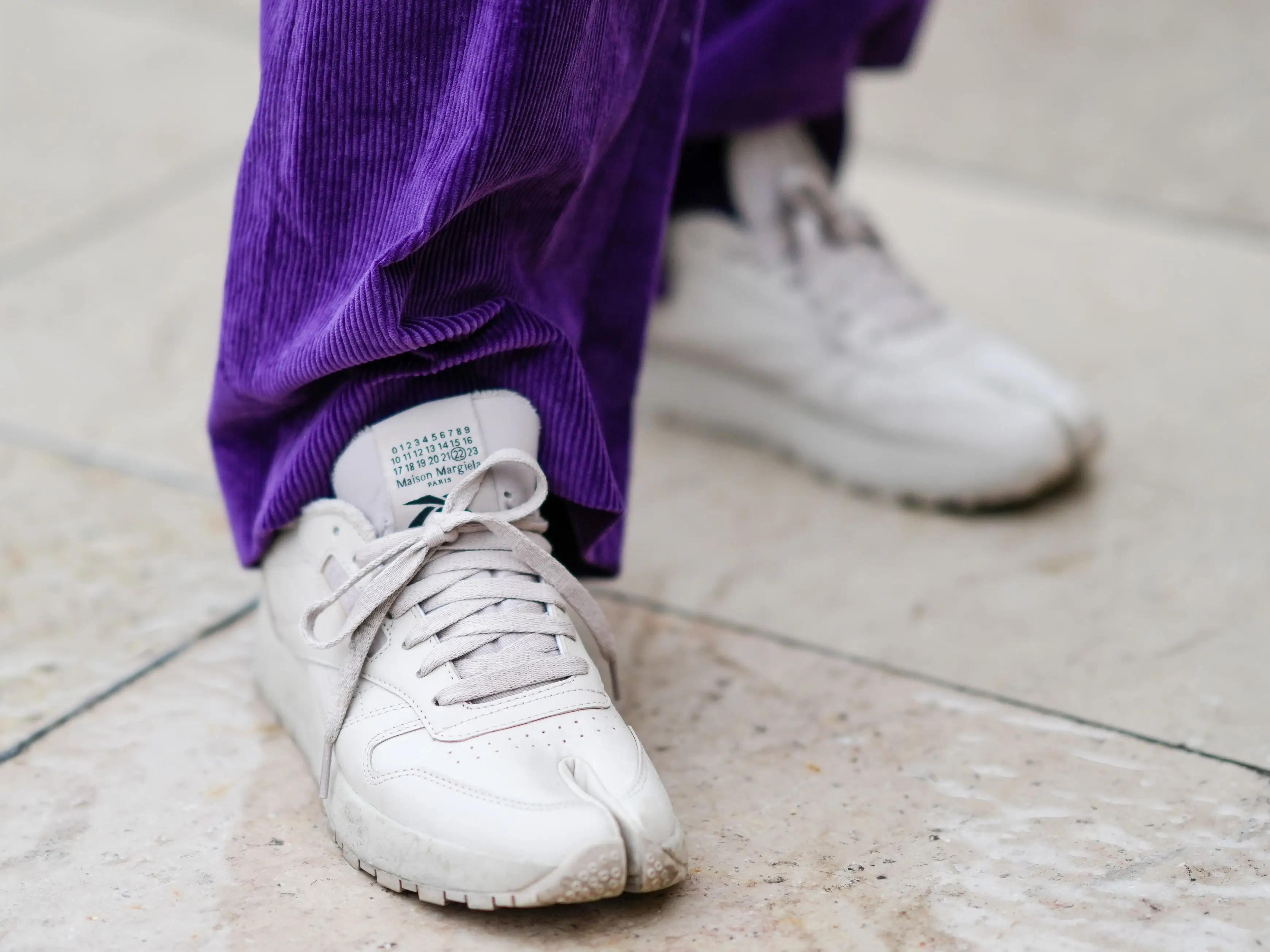 A white split-toe sneaker.