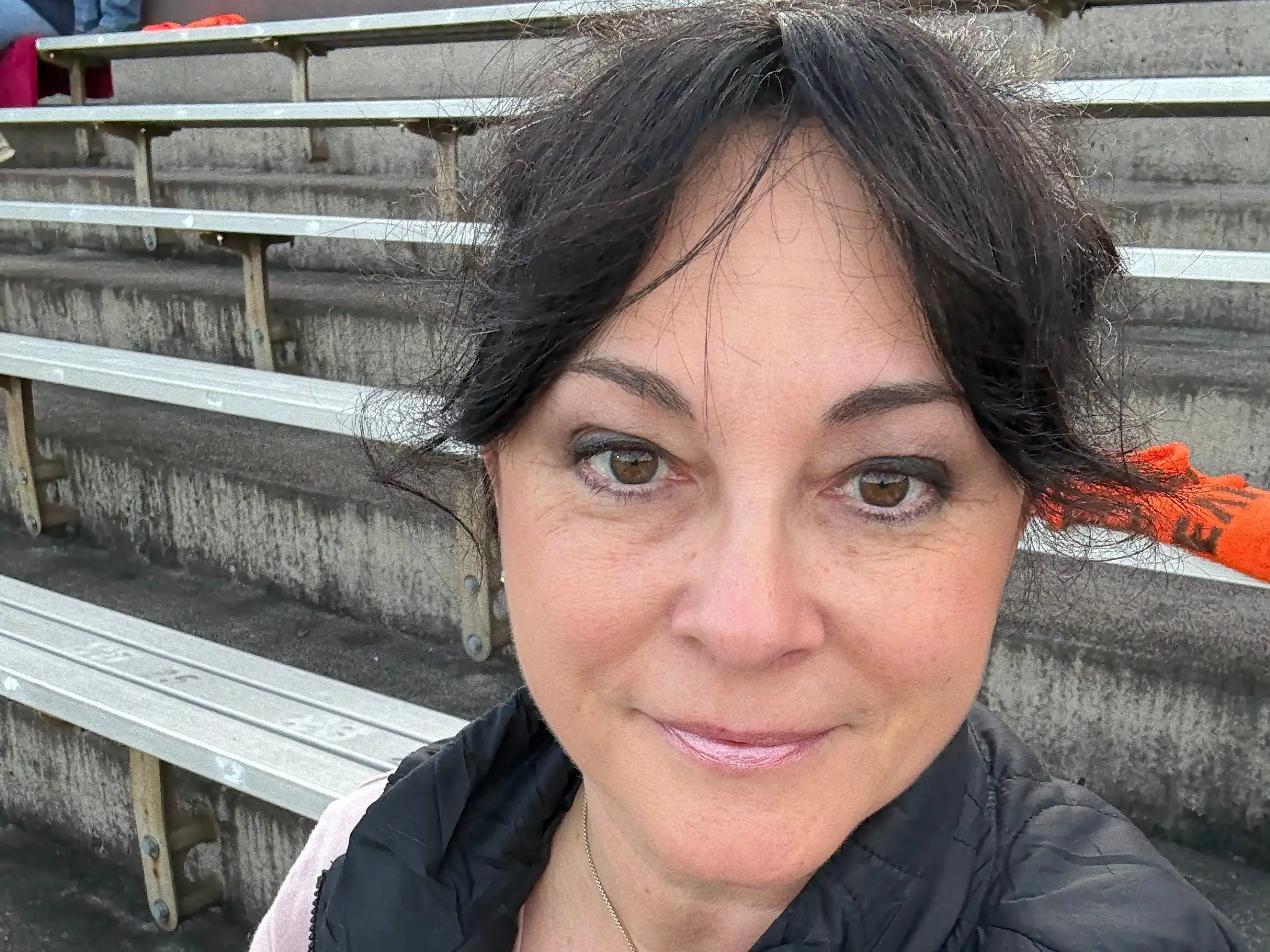 Nina McCollum sits in bleacher stands