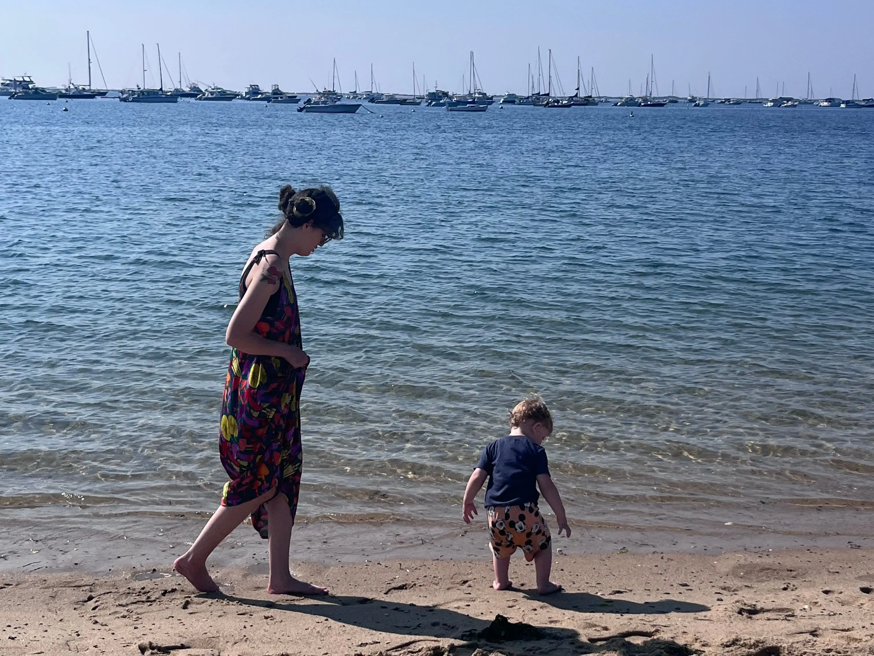 Woman and young boy walking along beach