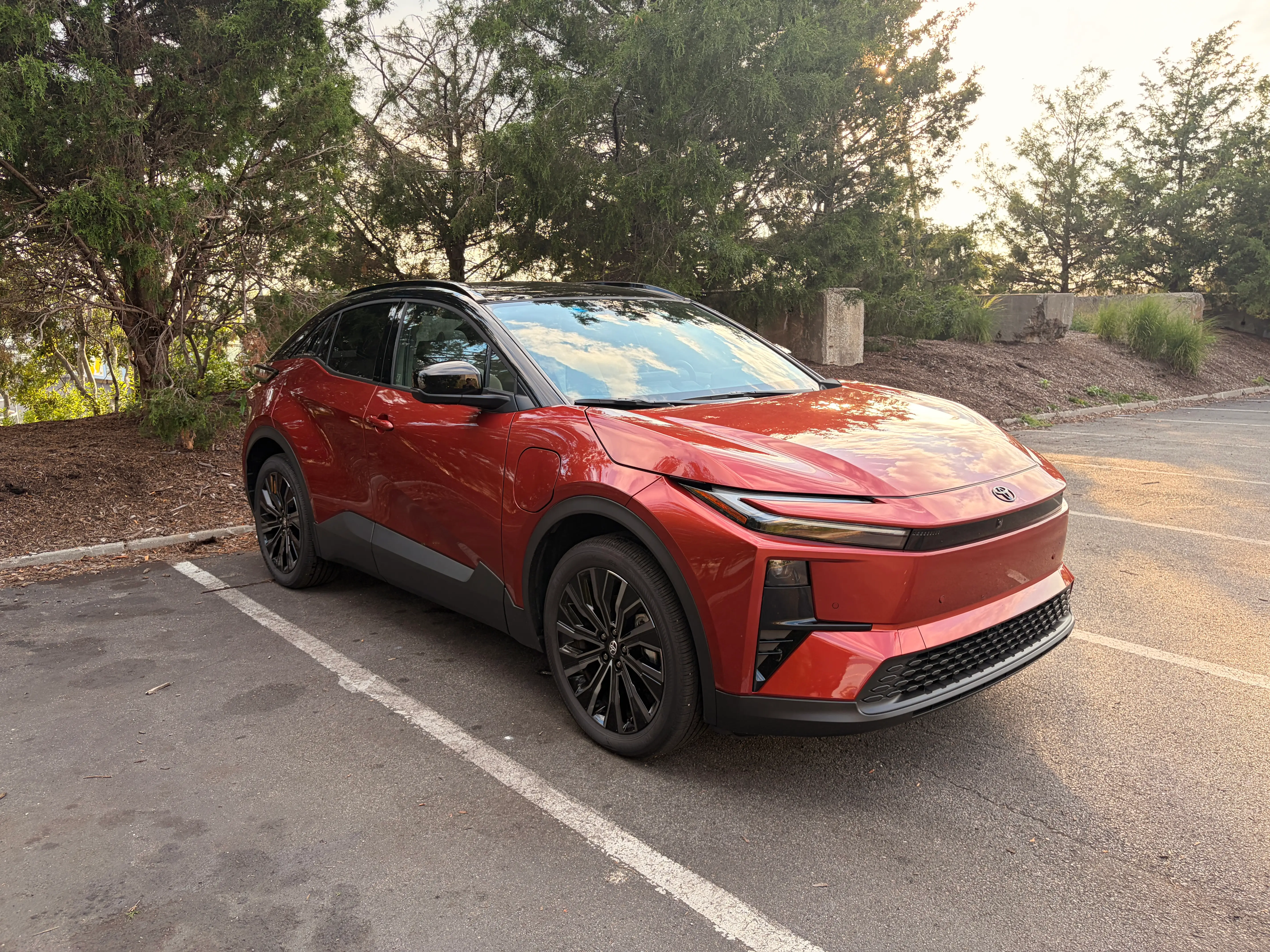 A burnt orange and black Toyota C-HR rests in a parking lot.