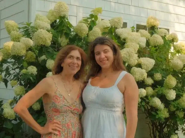 The author and her daughter pose in front of flowering hydrengeas.