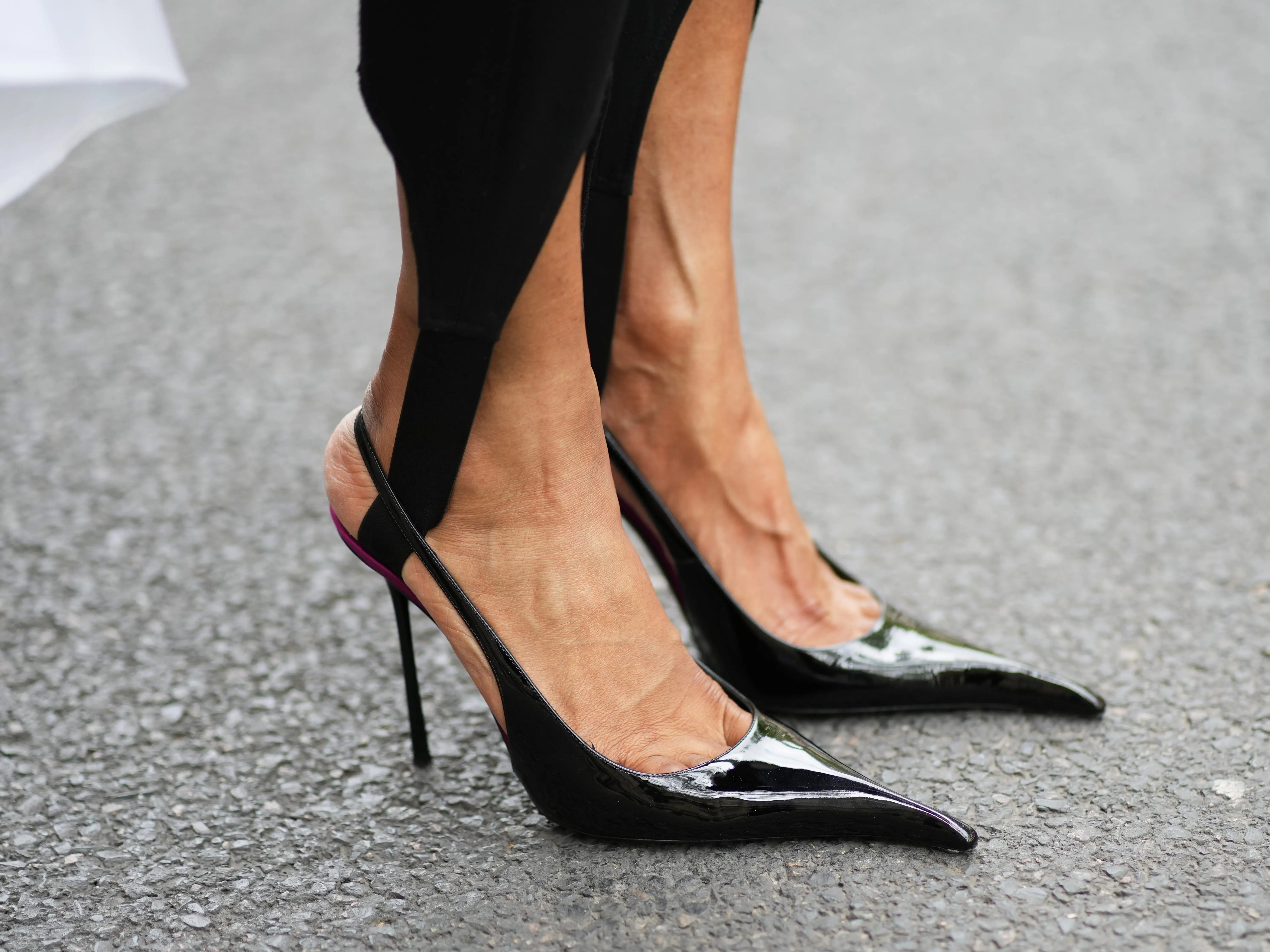 A woman wearing a pair of black stilettos.