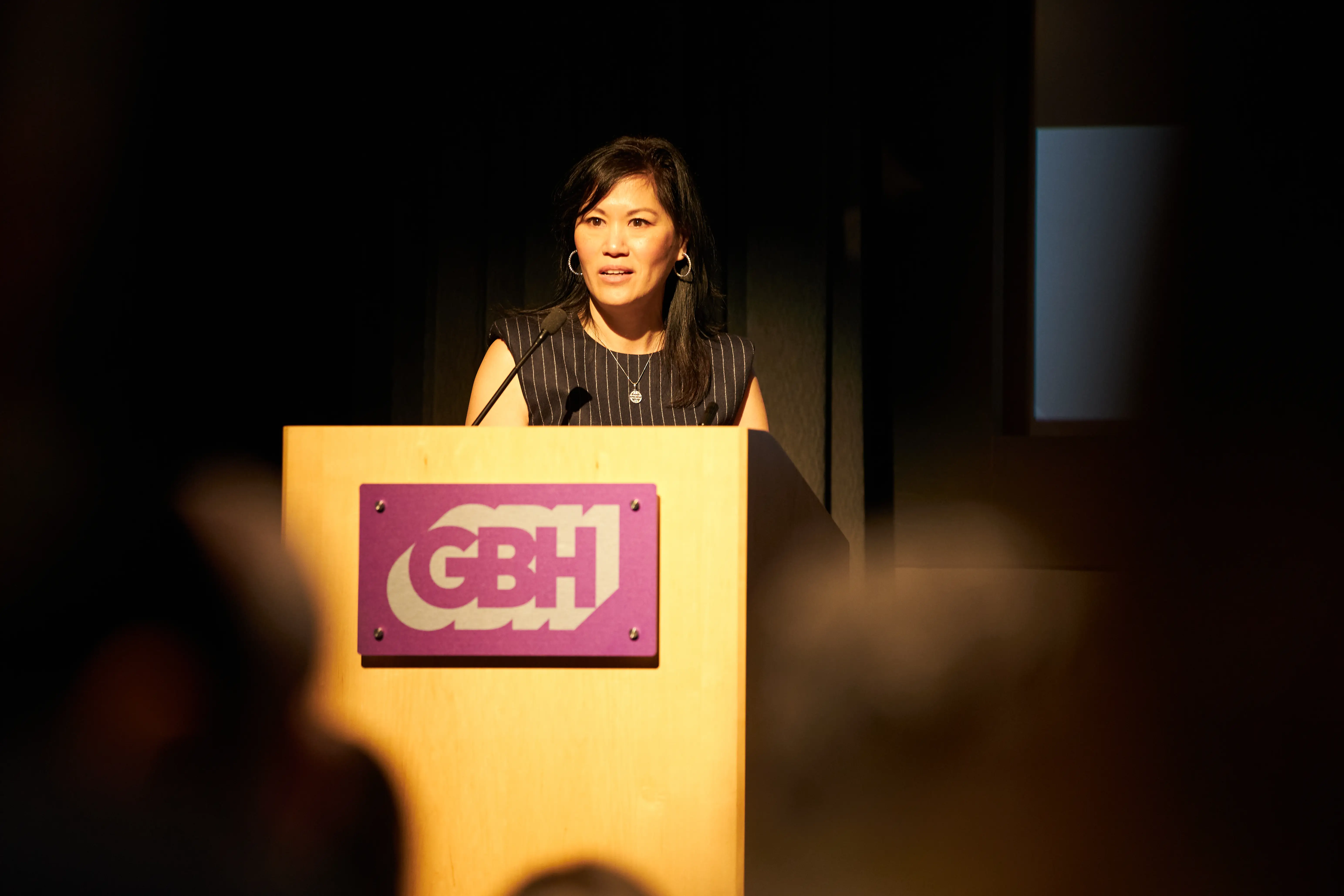 A woman giving an address at a conference.
