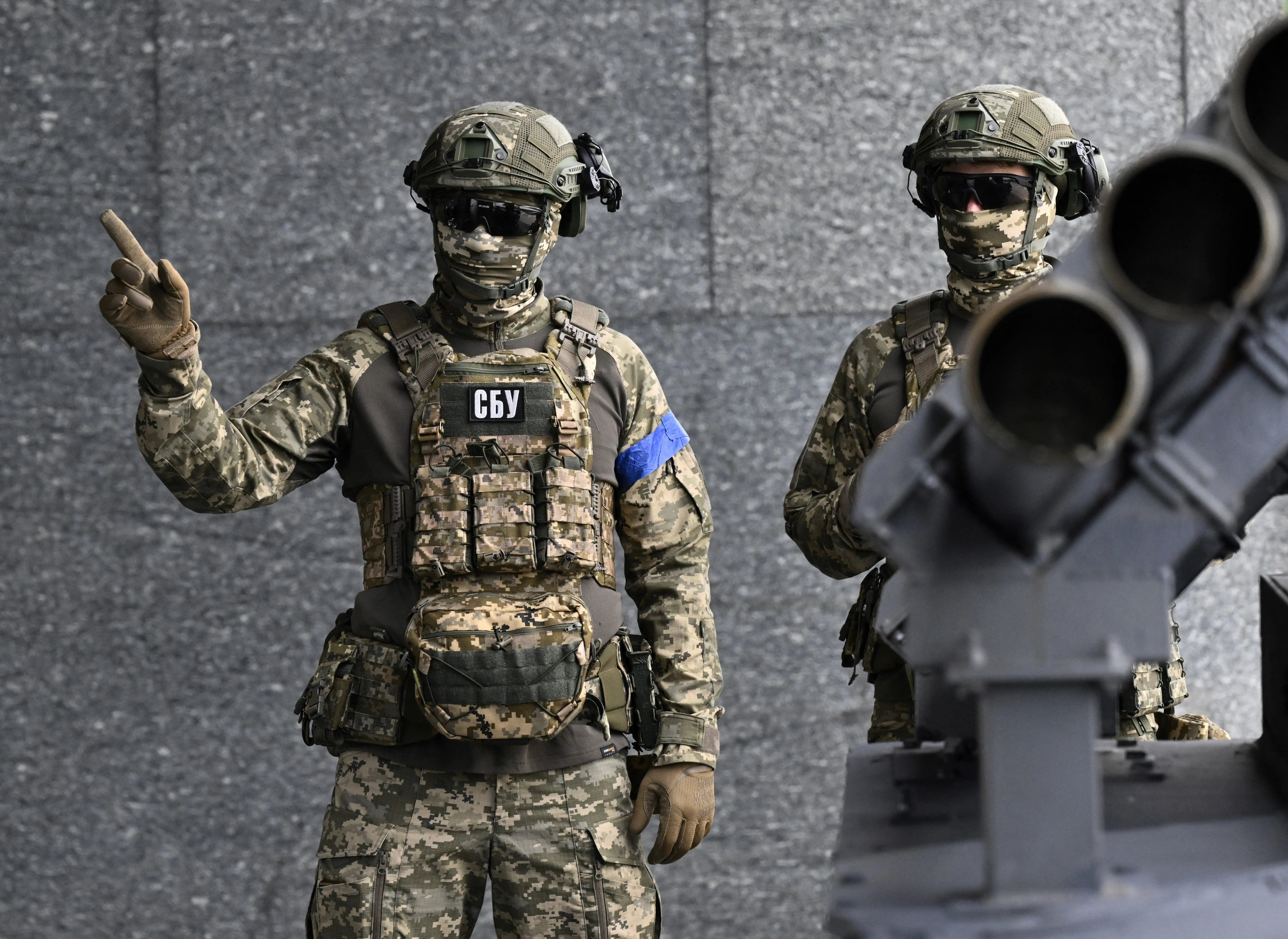 A member of the Security Service of Ukraine points upward.