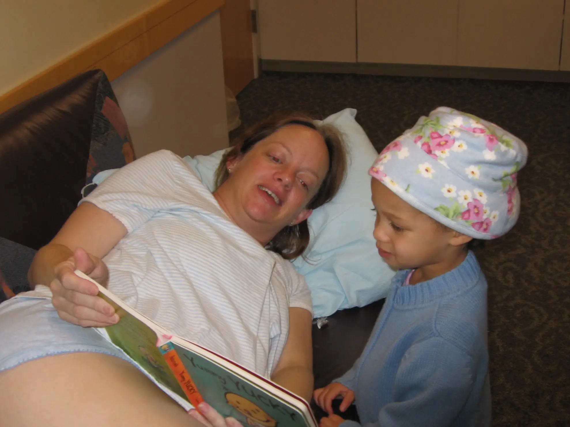 the author lying down reading a book to her toddler