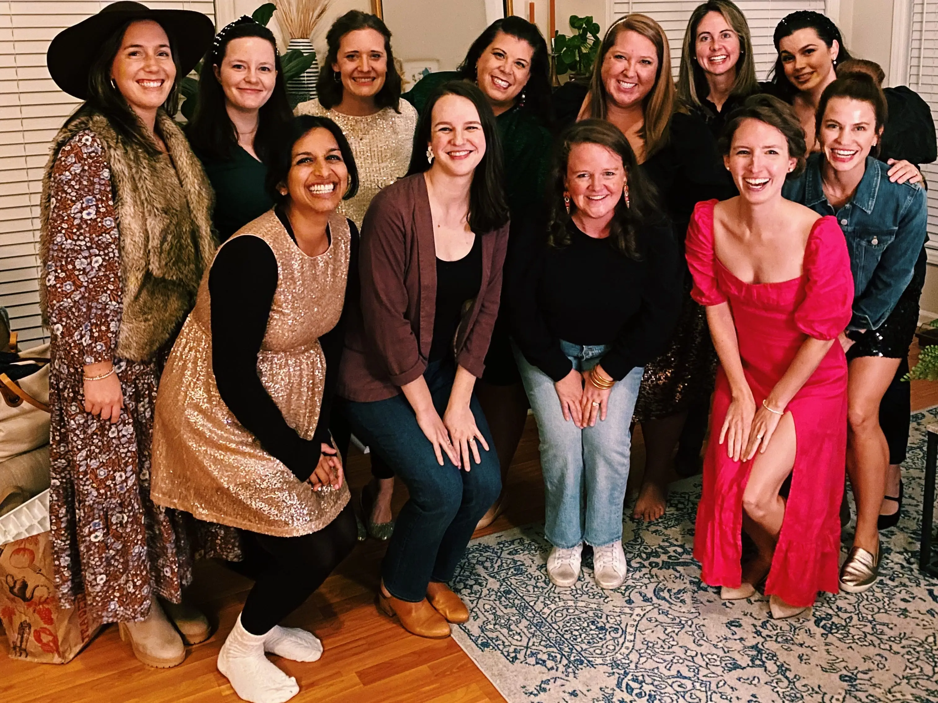 Eleven women pose inside a house while meeting for an article club.