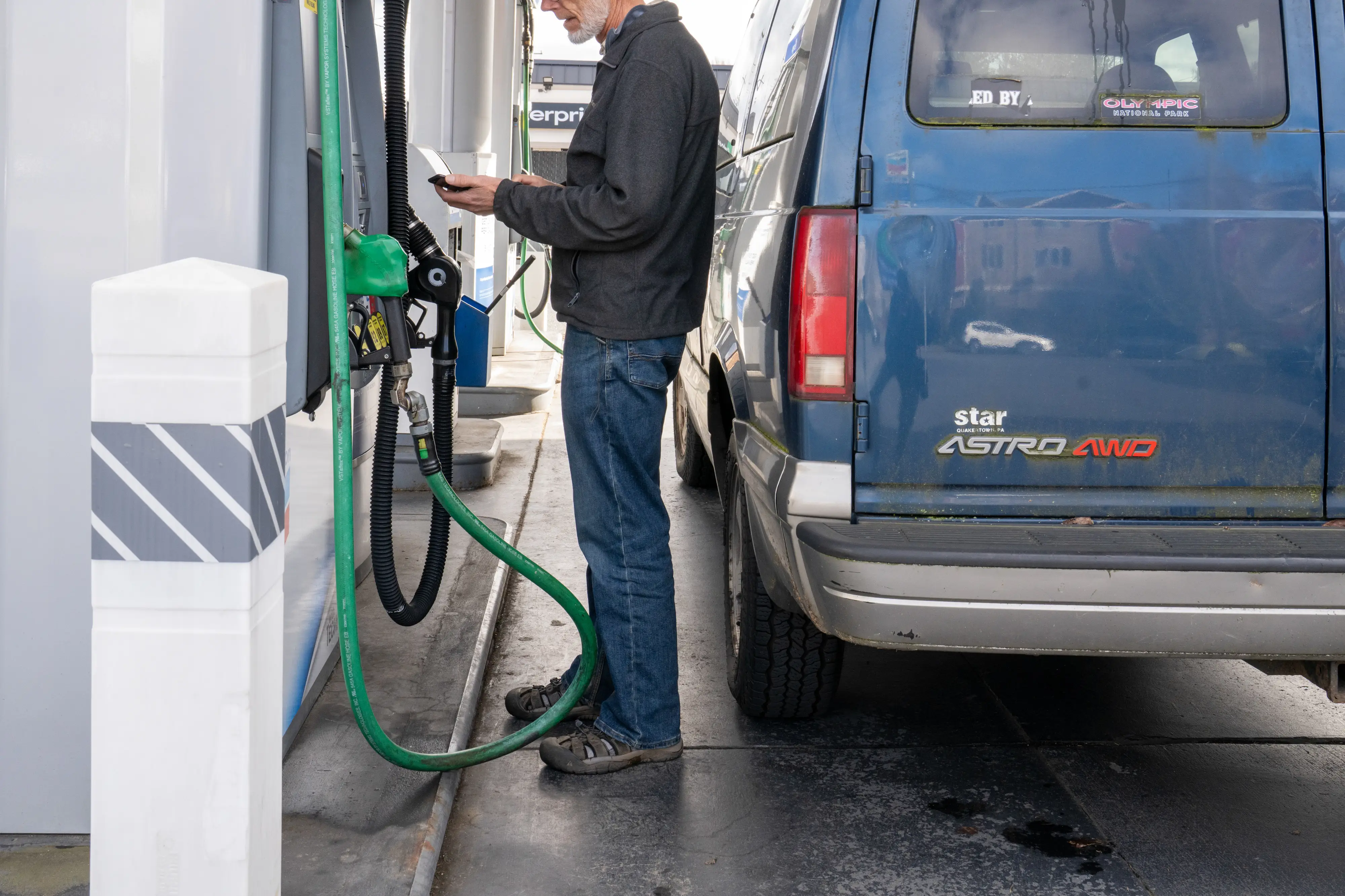 A man buys gas at a gas station pump.