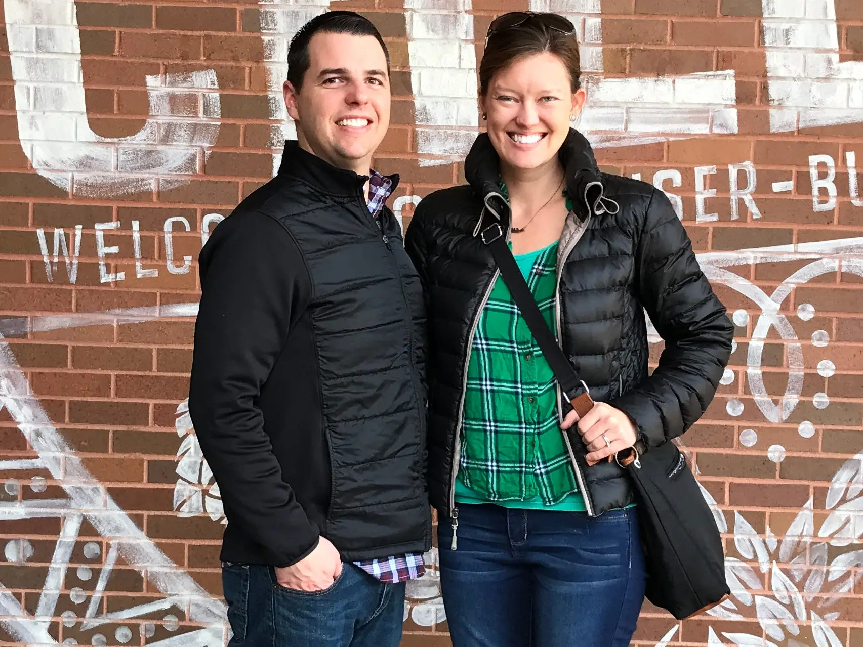 The author and her husband pose in front of a mural that reads 