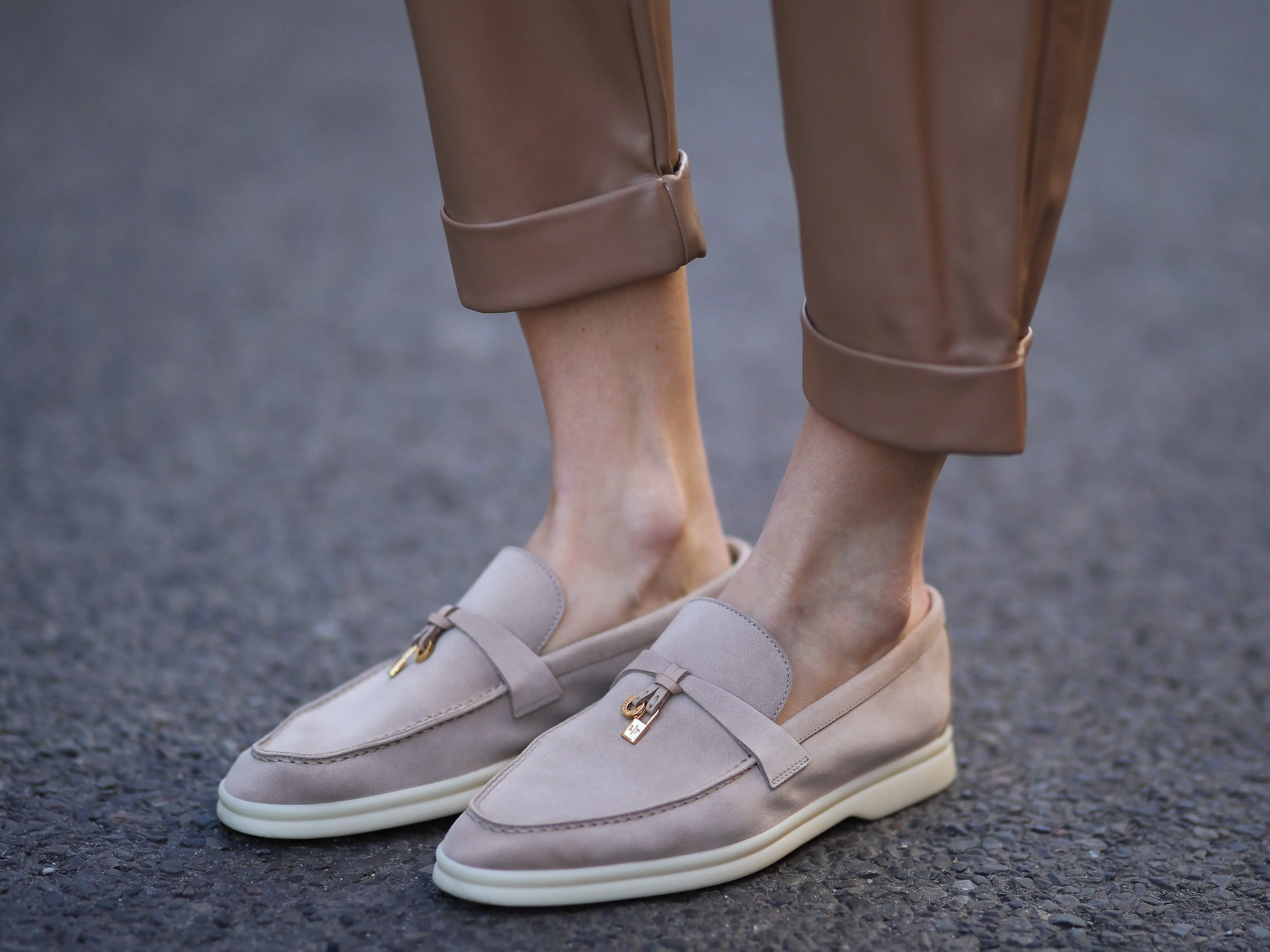 A person wearing a pair of beige loafers.