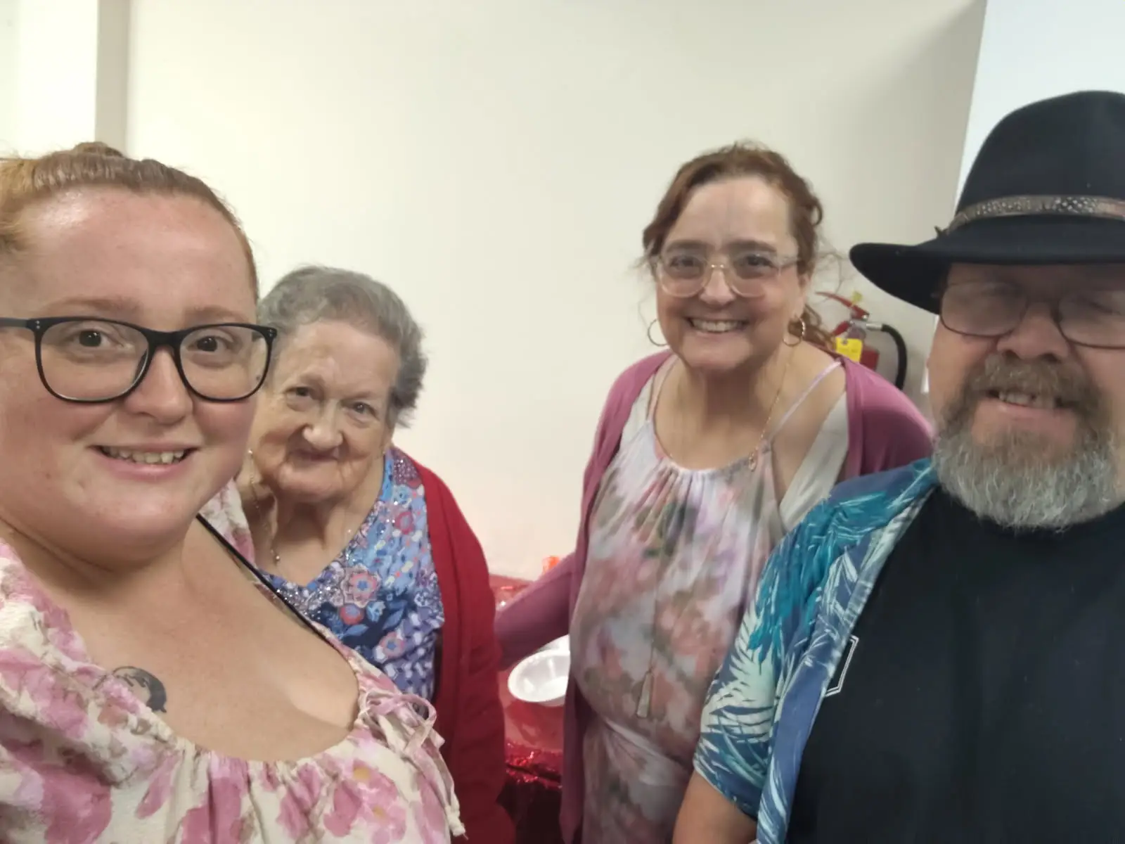 Four people, representing three generations, taking a selfie.