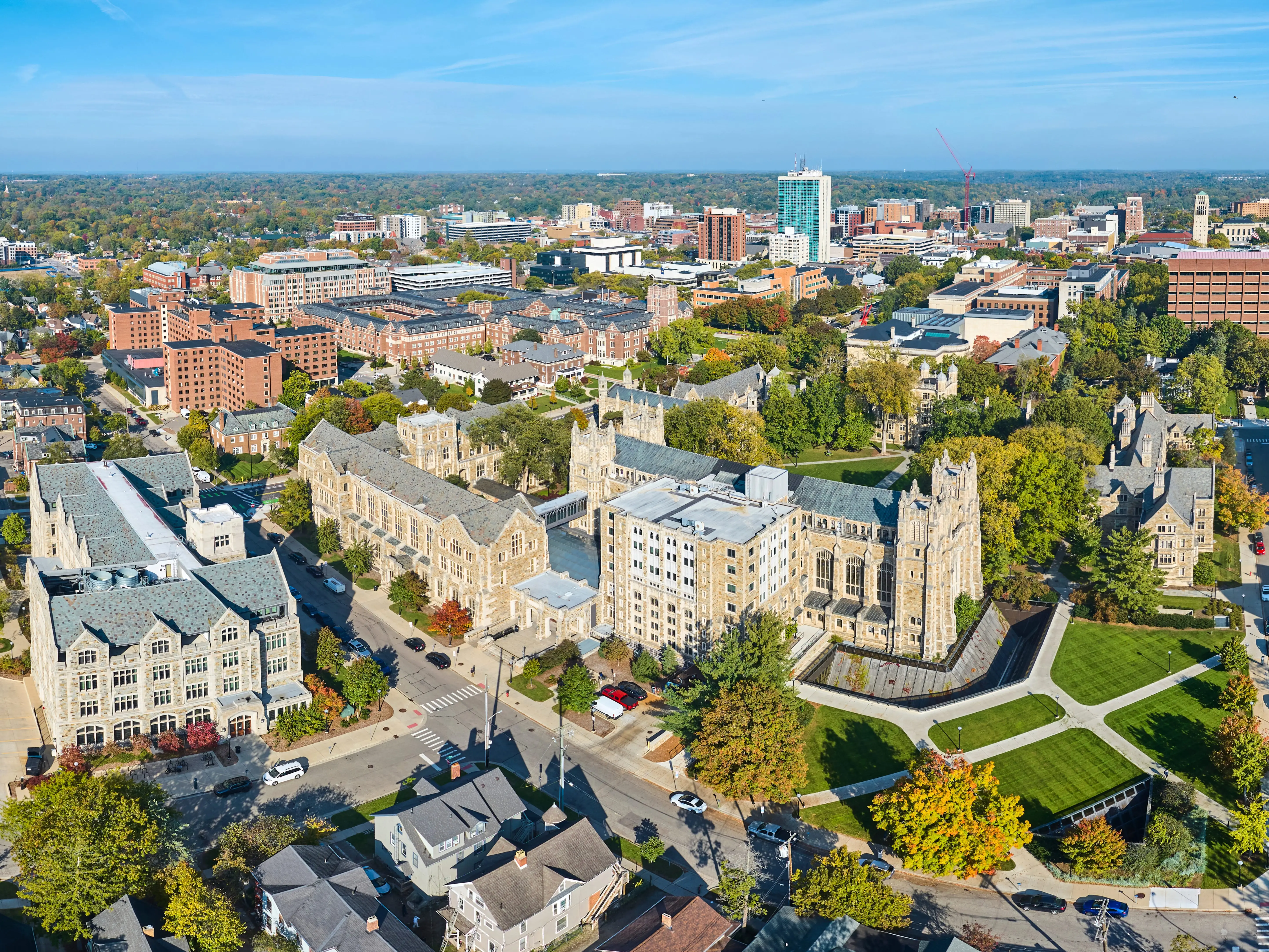 Aerial panorama of the University of Michigan campus showcasing Gothic architecture, vibrant autumn foliage and bustling city life.