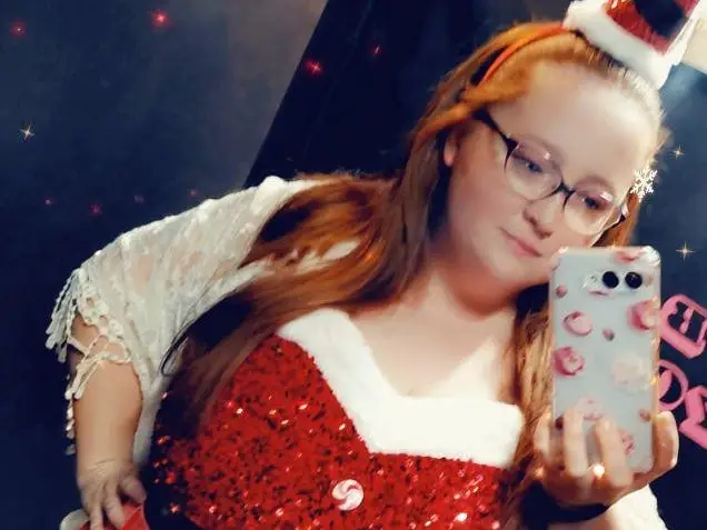A woman dressed for the holidays in a Santa outfit.
