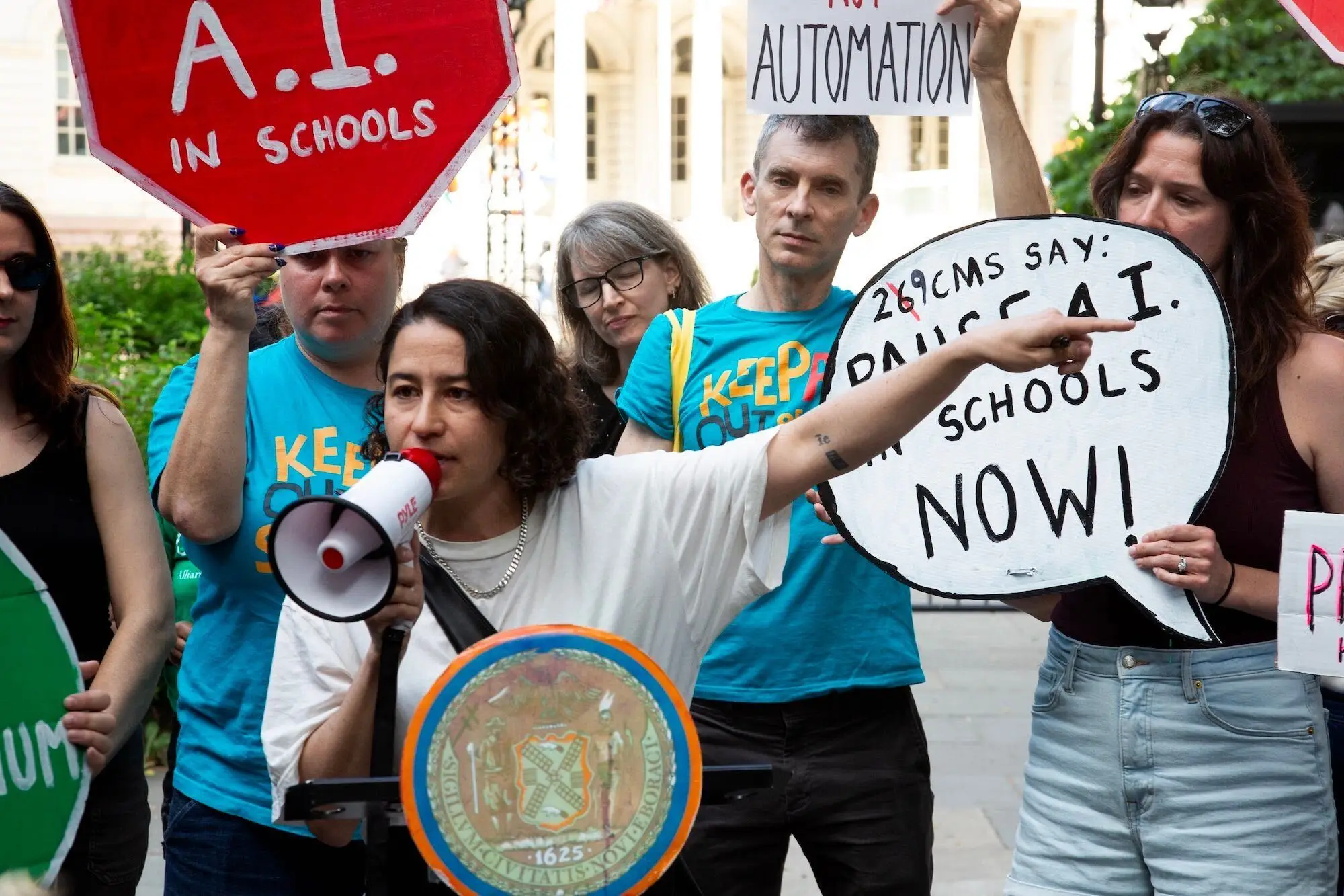 Ilana Glazer speaking into a megaphone at an anti-AI rally in New York City in June.