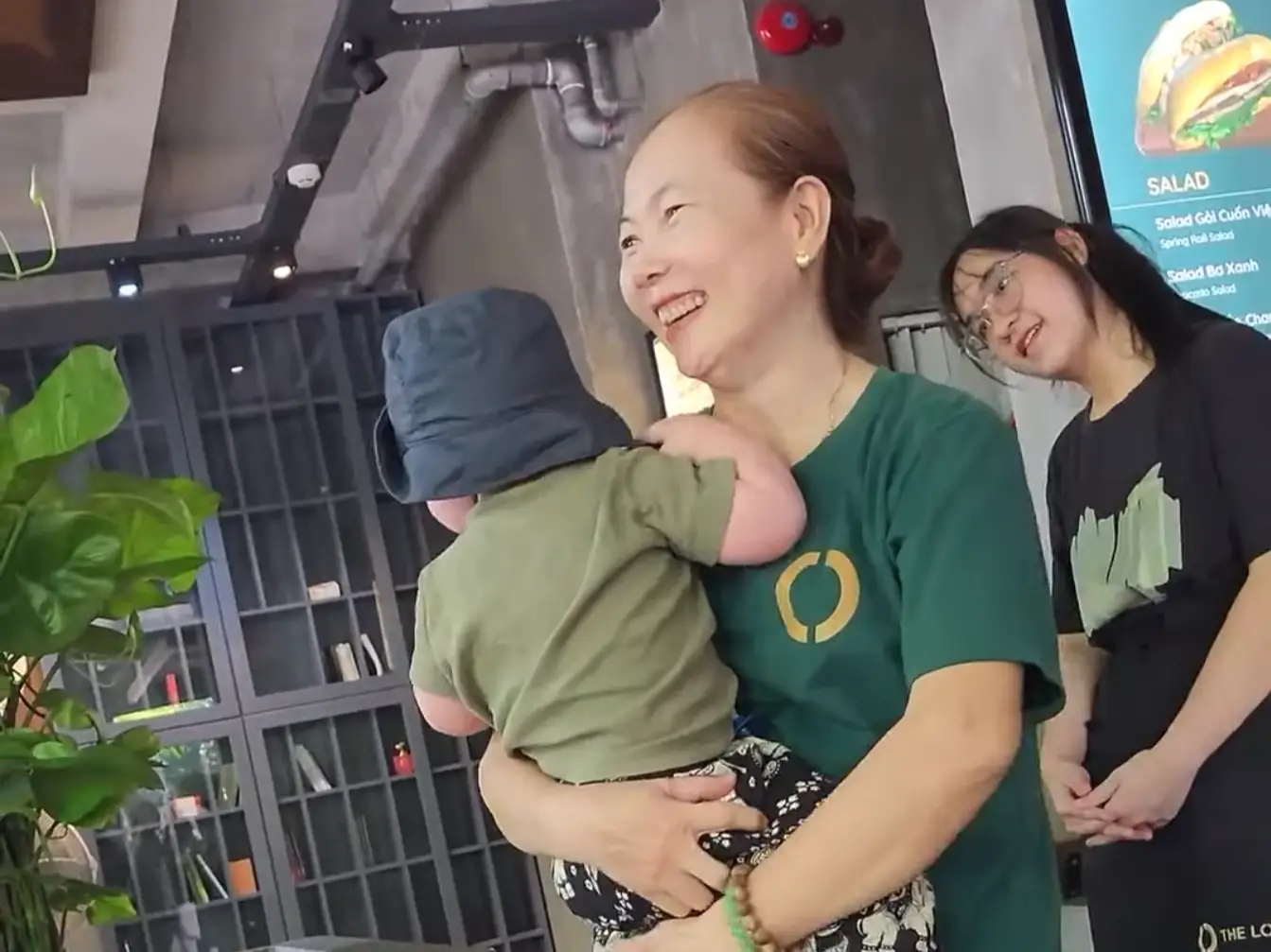 Restaurant staff carryign a baby.