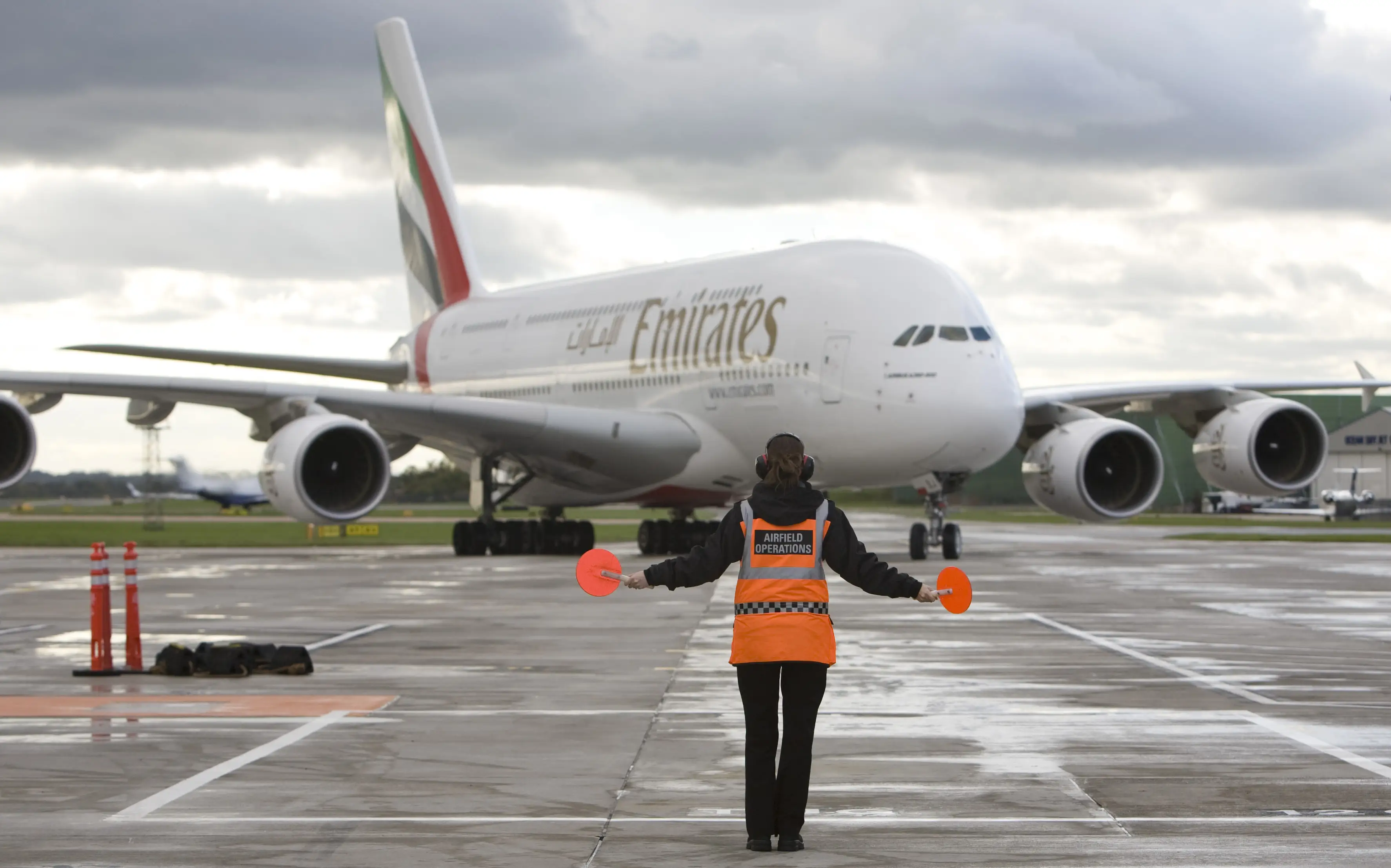 An Emirates Airline Airbus A380 airplane is directed on to a stand at Manchester airport in Manchester, U.K., on Thursday, Oct. 21, 2010