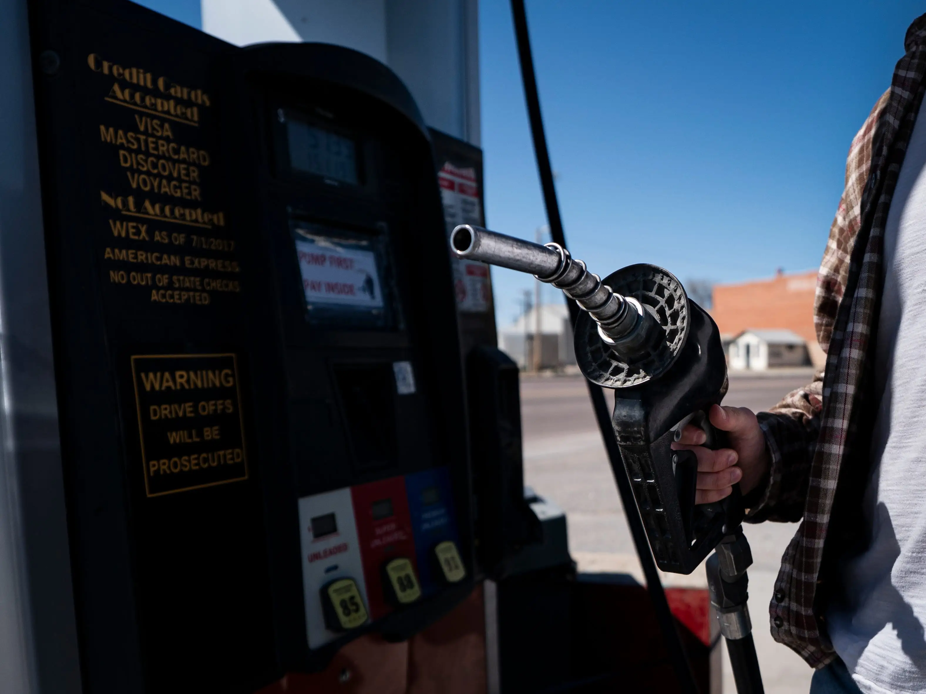 A man holds a gas pump.