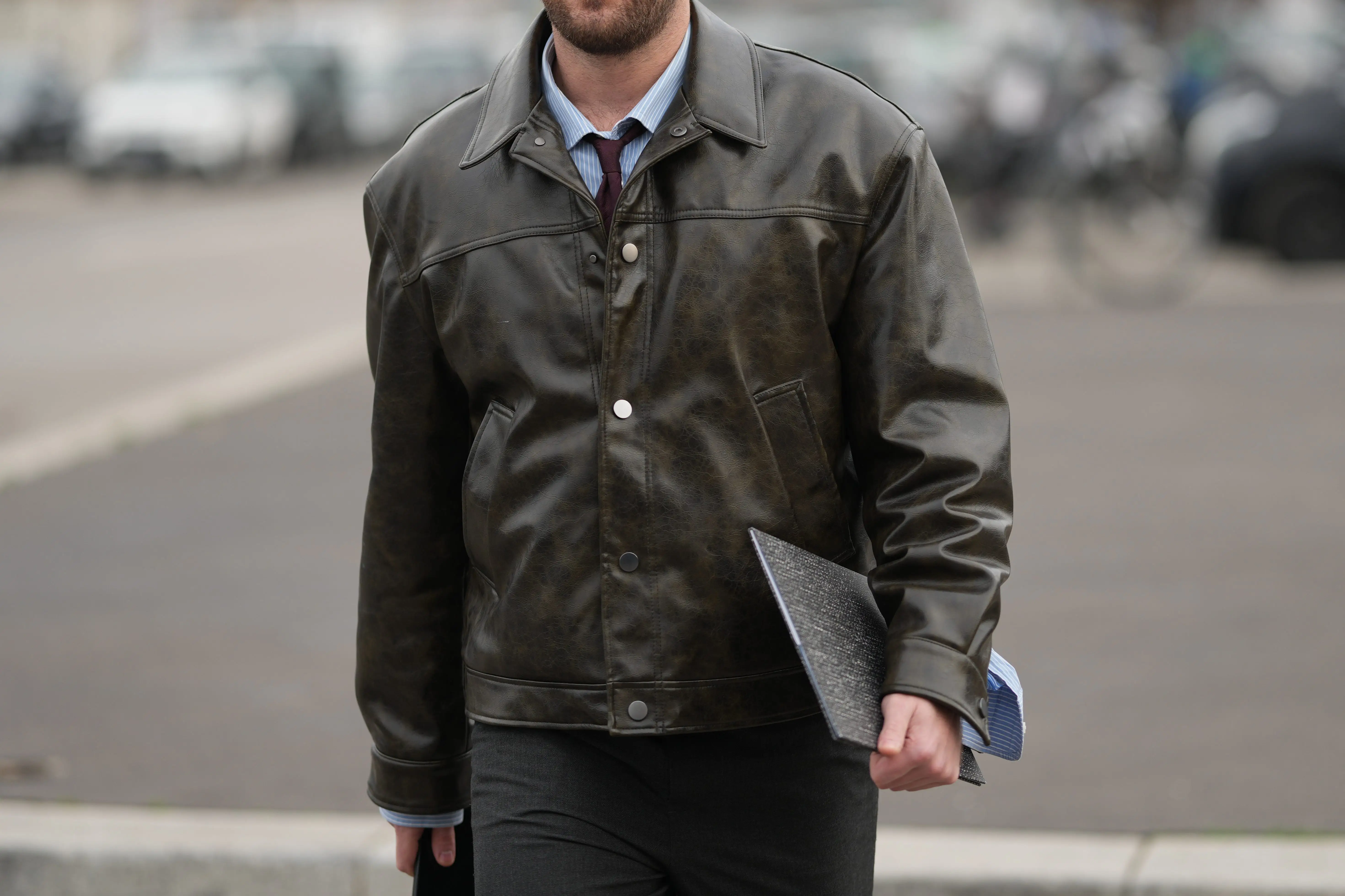 Man in leather jacket holding folder