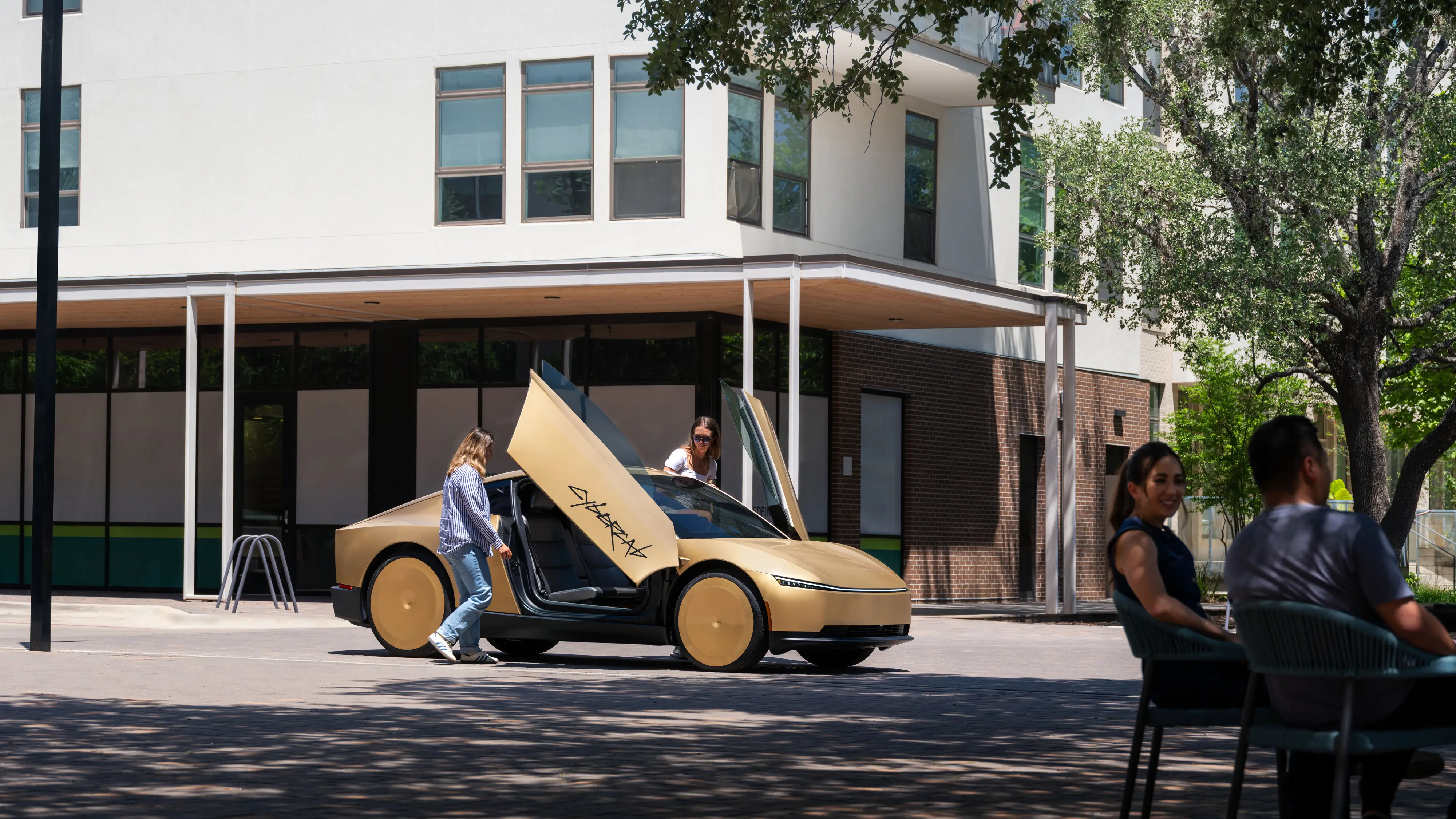 Two occupants get into a gold Tesla Cybercab.