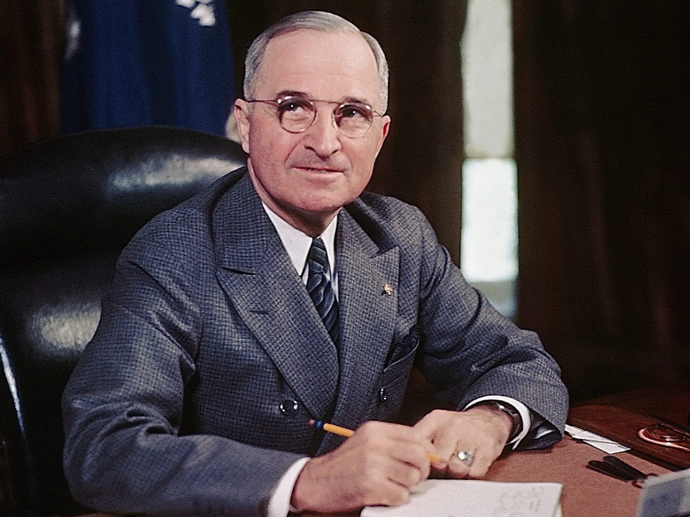 4/1946: President Harry S. Truman seated at his desk holding a pencil.
