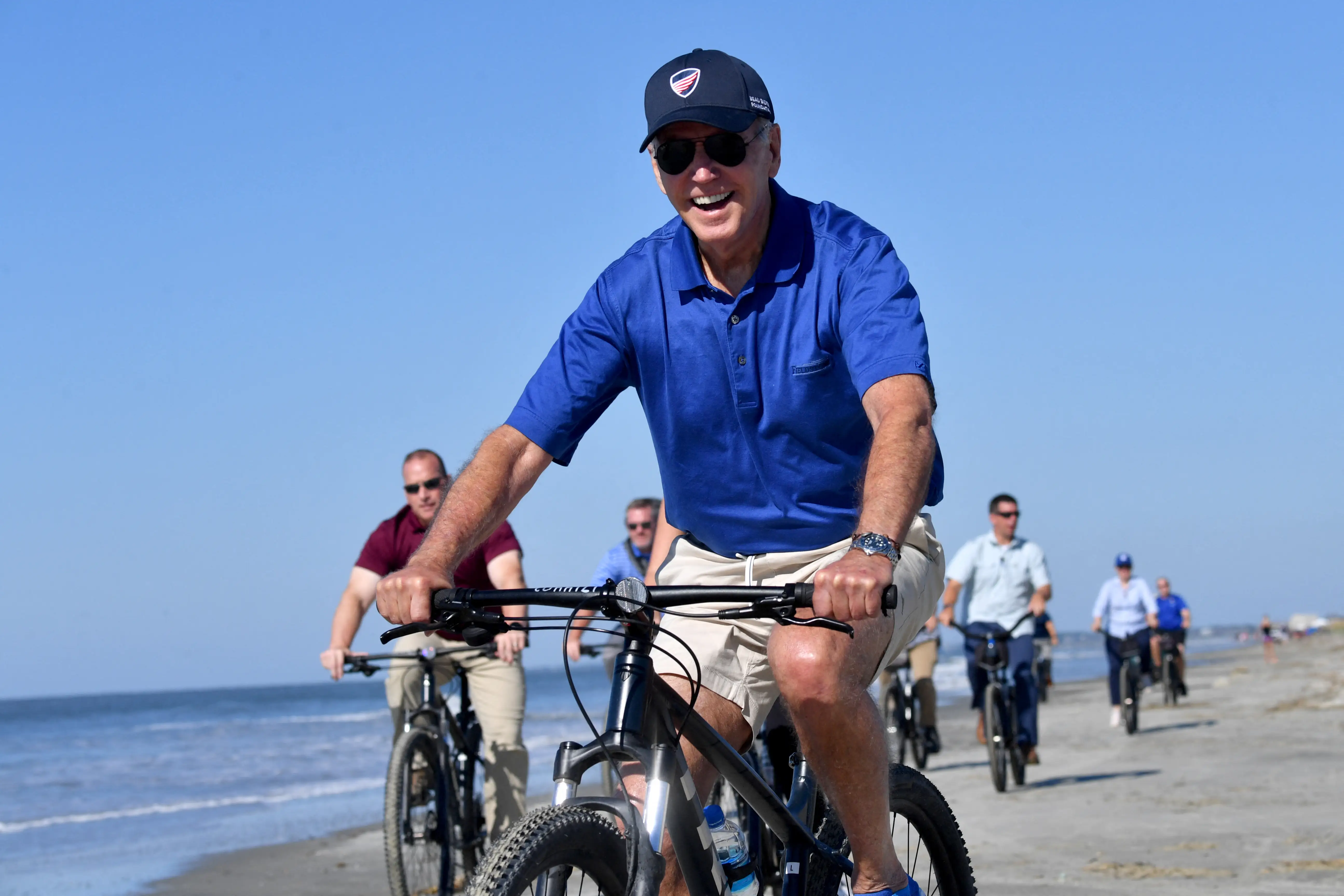 US President Joe Biden rides his bicycle along the beach while on vacation in Kiawah Island, South Carolina, on August 14, 2022.