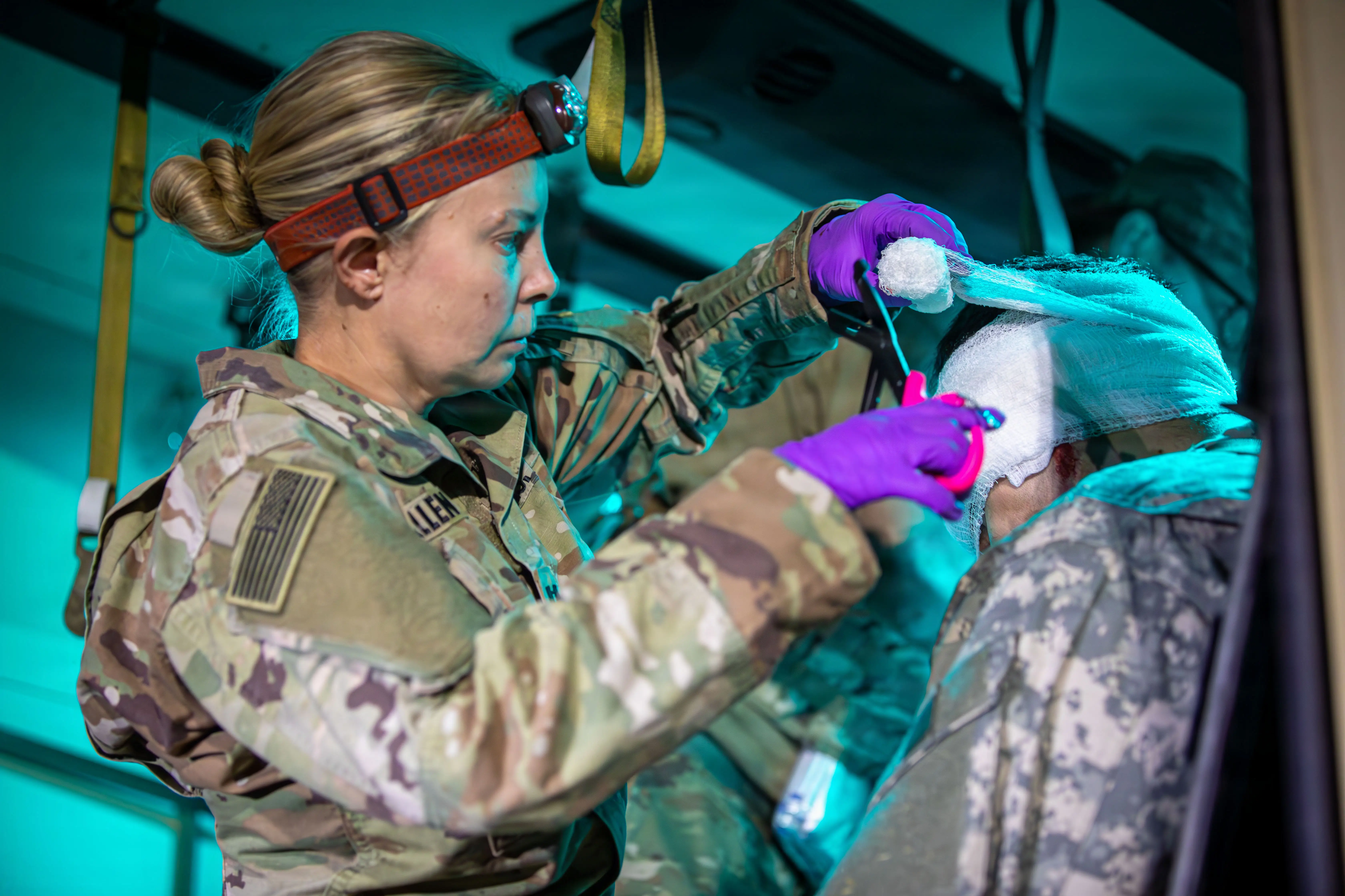 A soldier wraps a casualty's head wound during a training event at Fort Hunter Liggett, California, July 16, 2026.