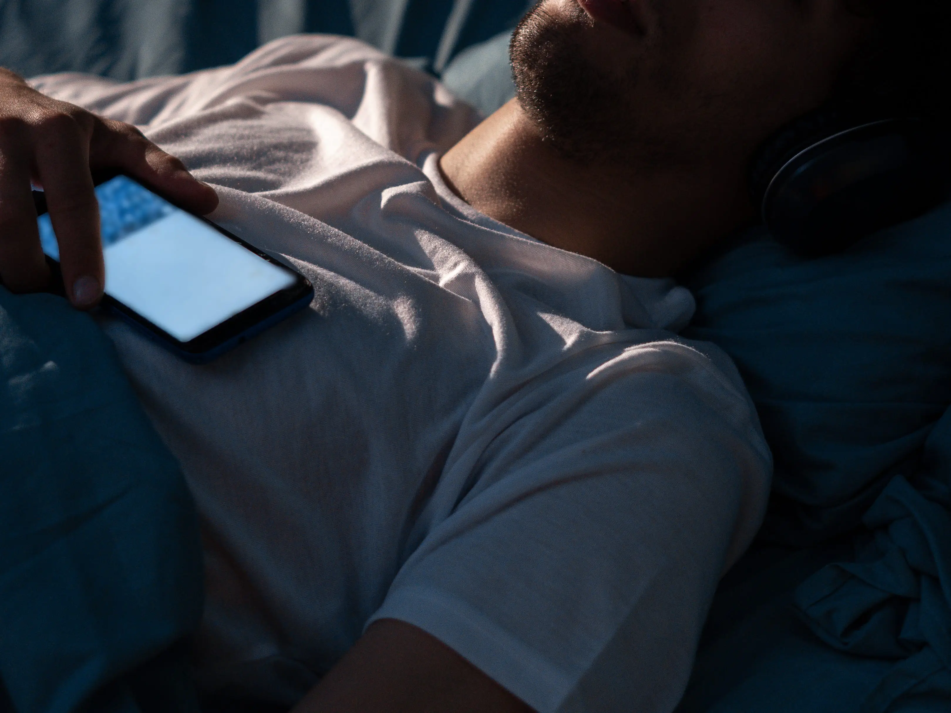 Man listening to audio in bed