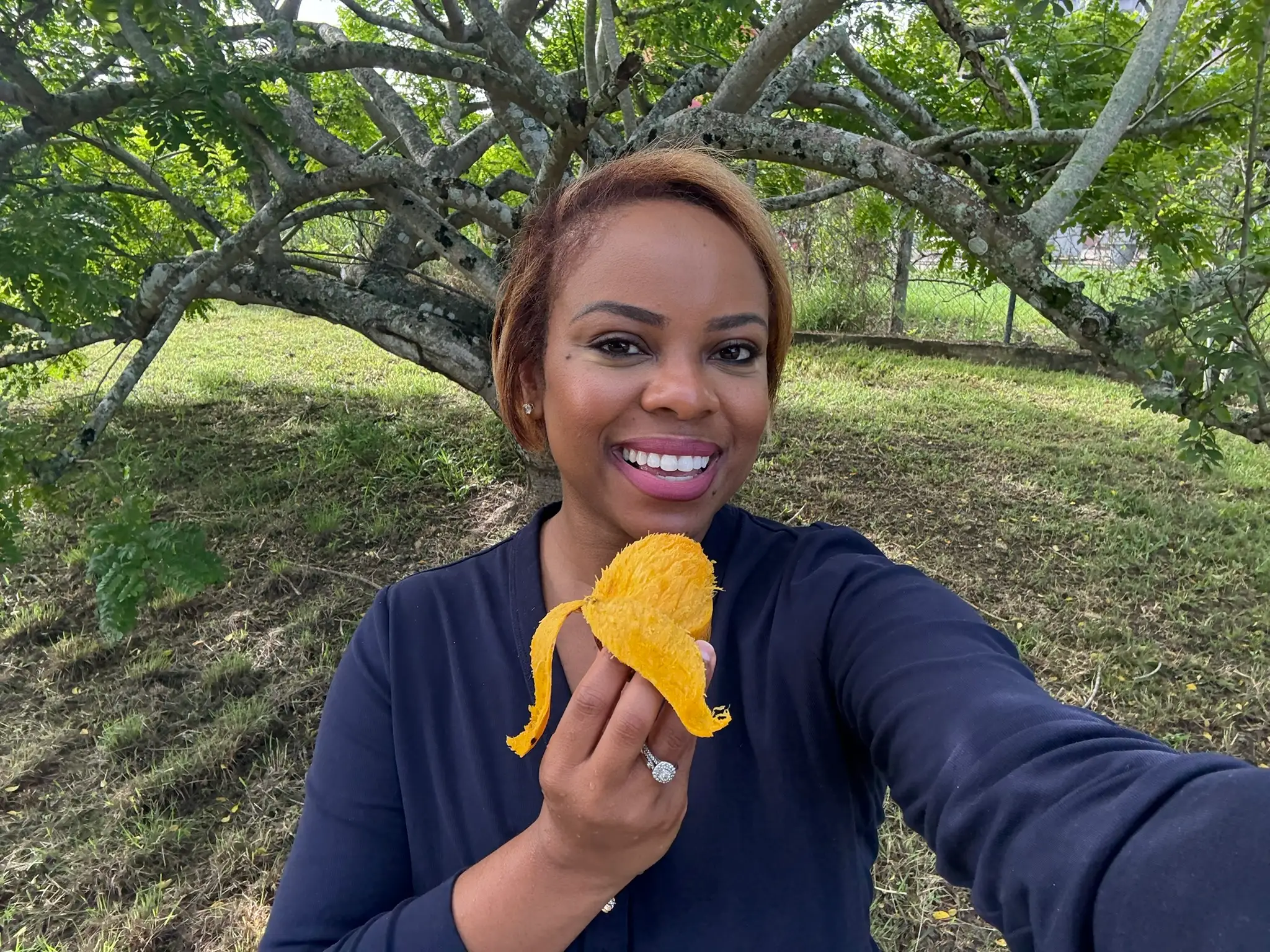 Woman smiling with a mango in hand