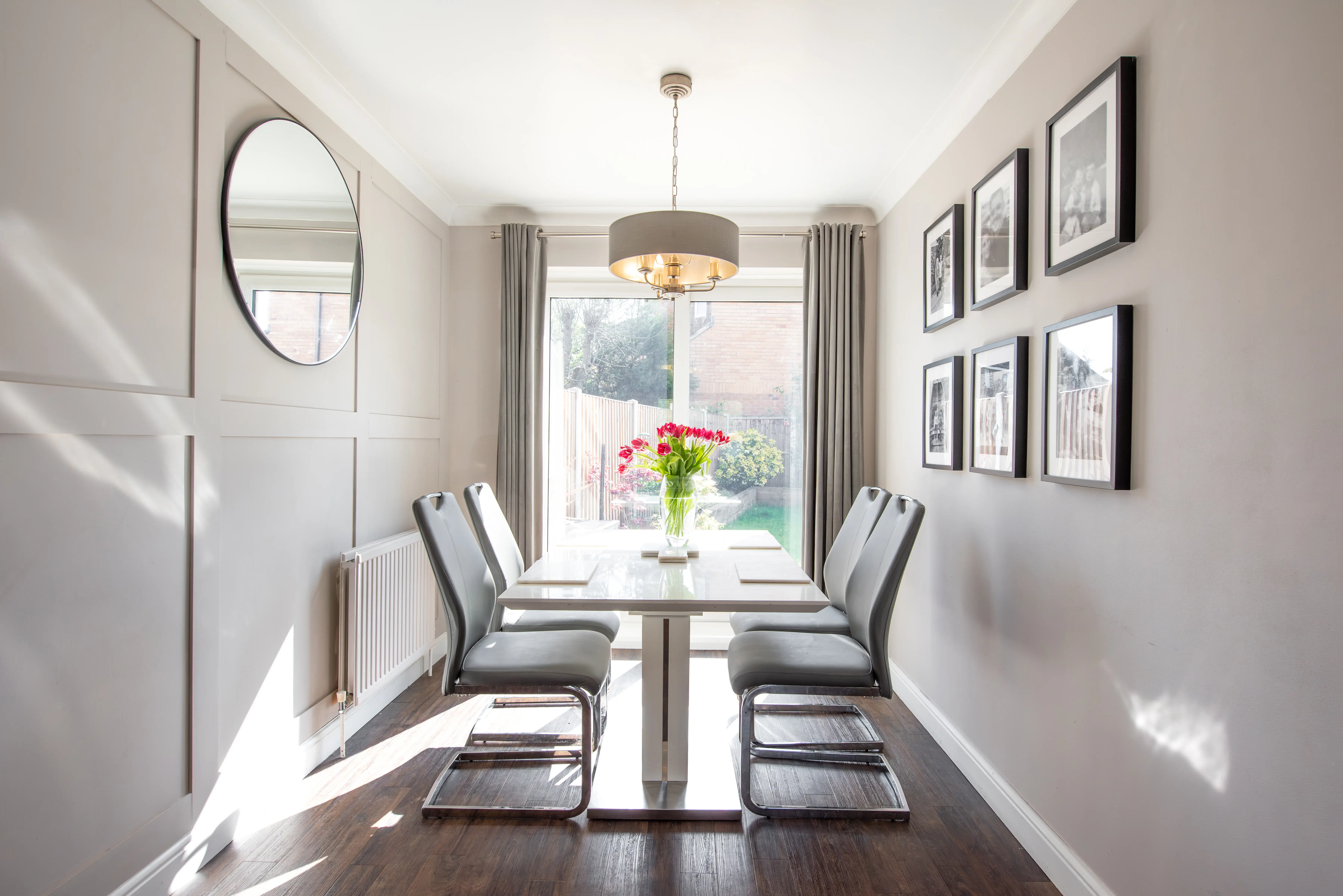 dining room with modern chrome and quartz dining table and chairs with wood paneling