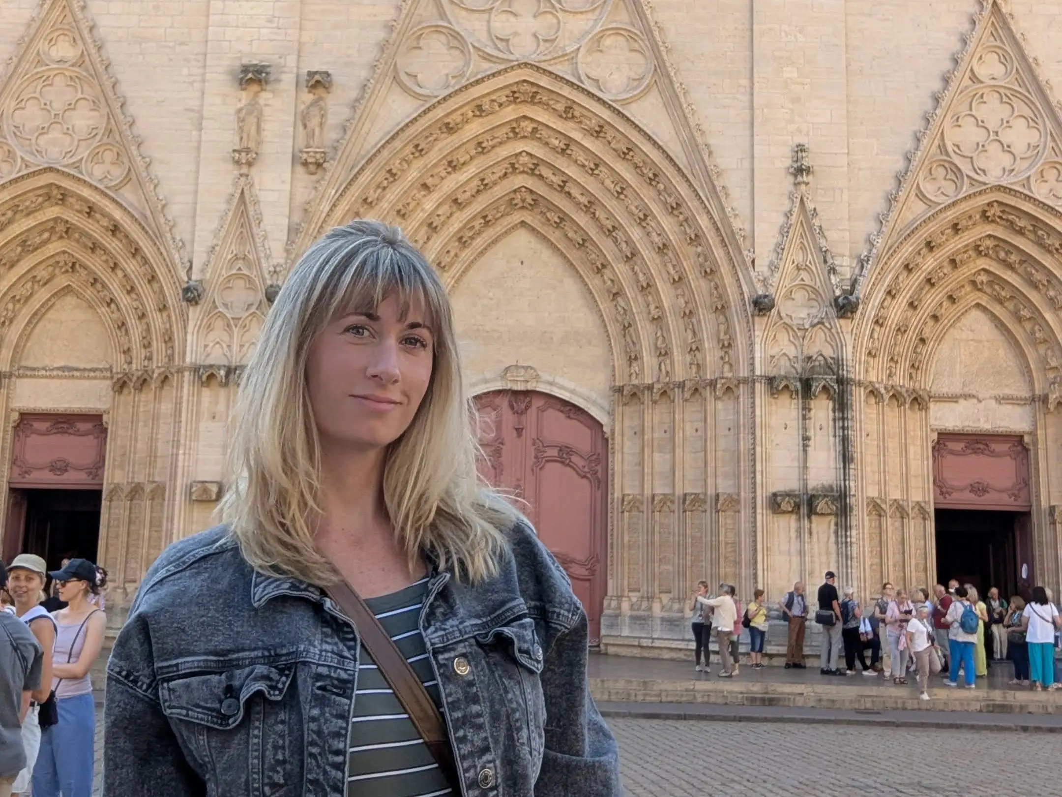 Leah Young stands in front of a window of Lyon Cathedral.