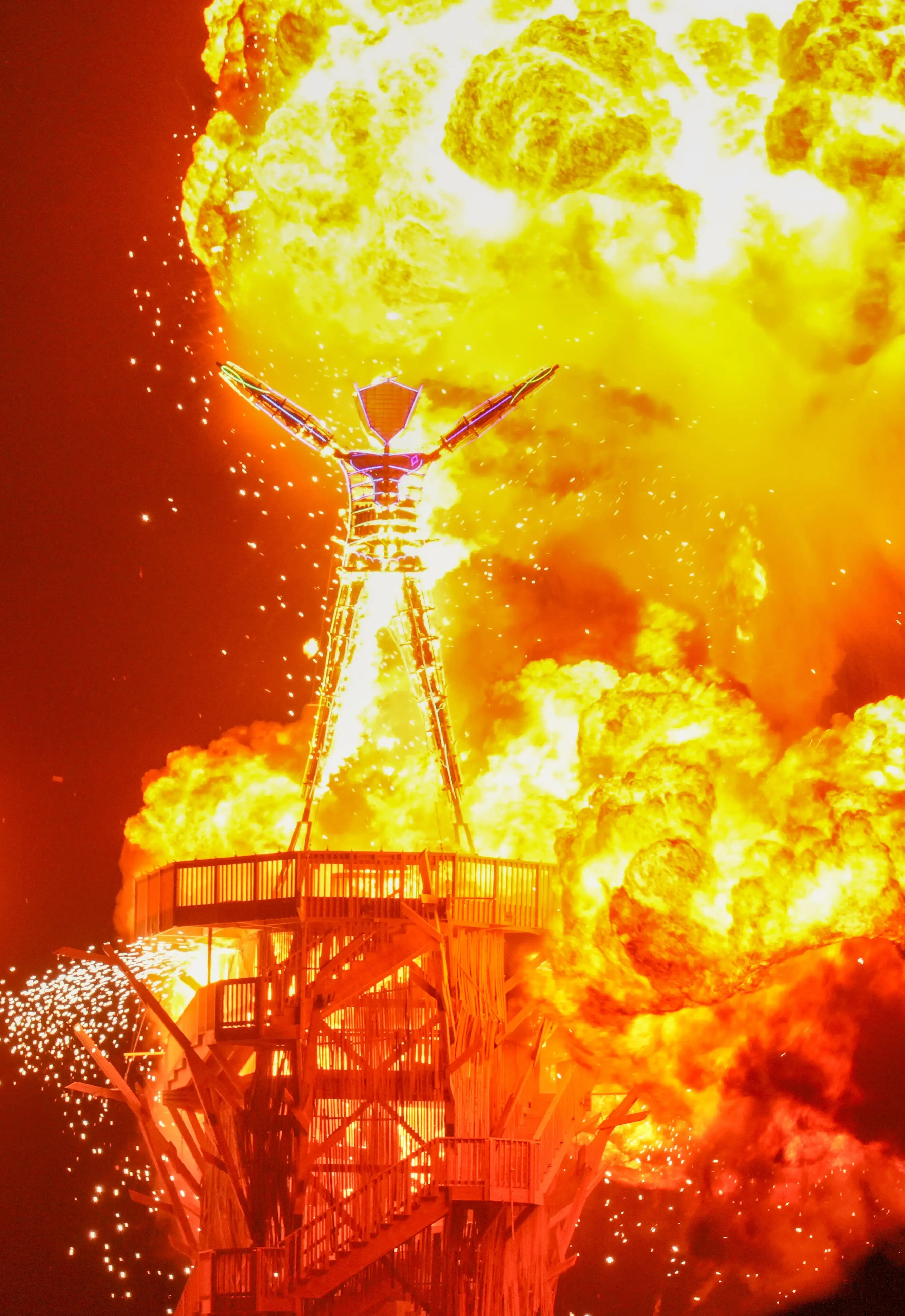 Large wooden effigy burns amid intense flames and sparks.