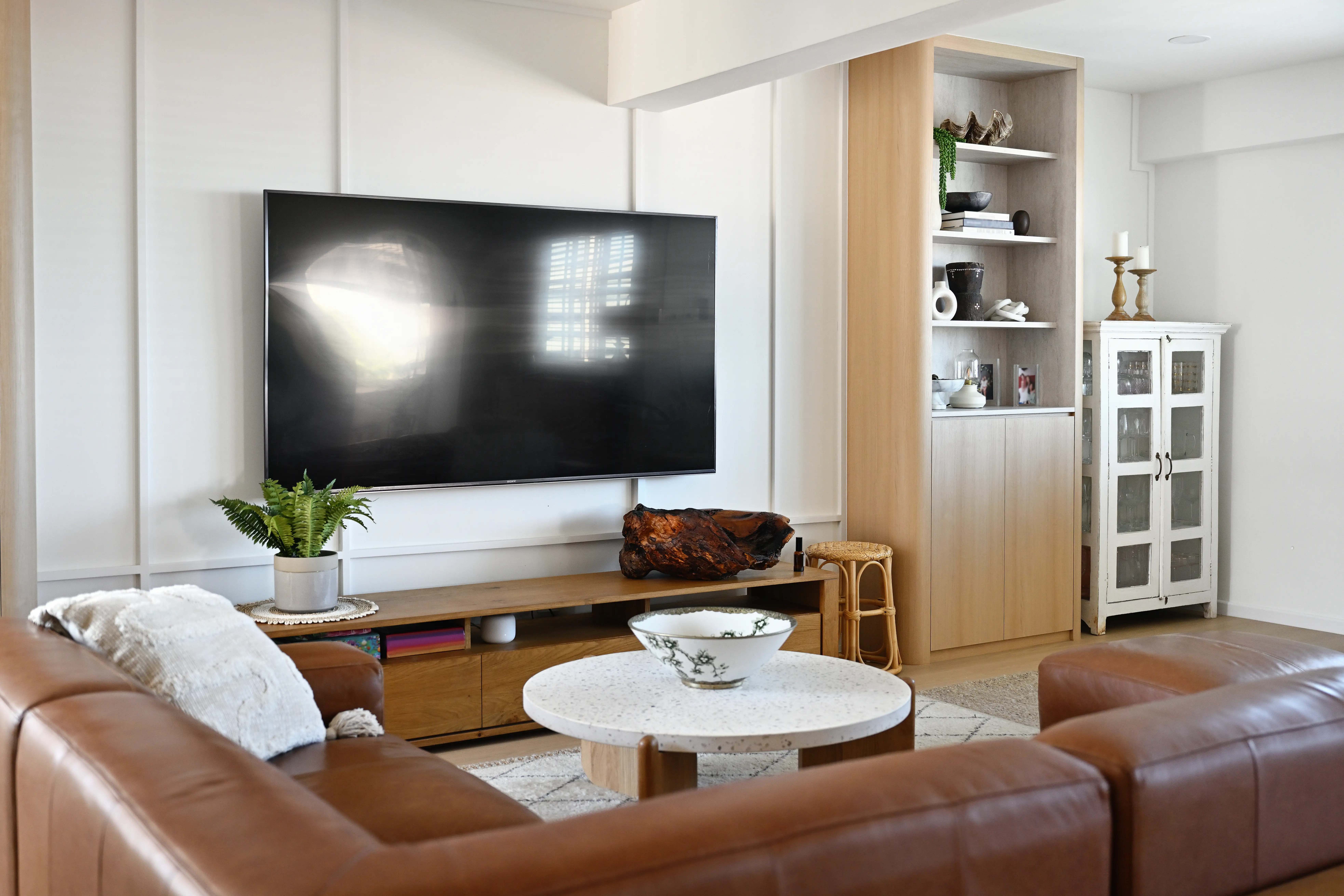 Living room with mounted tv, cabinets next to it, tv stand below