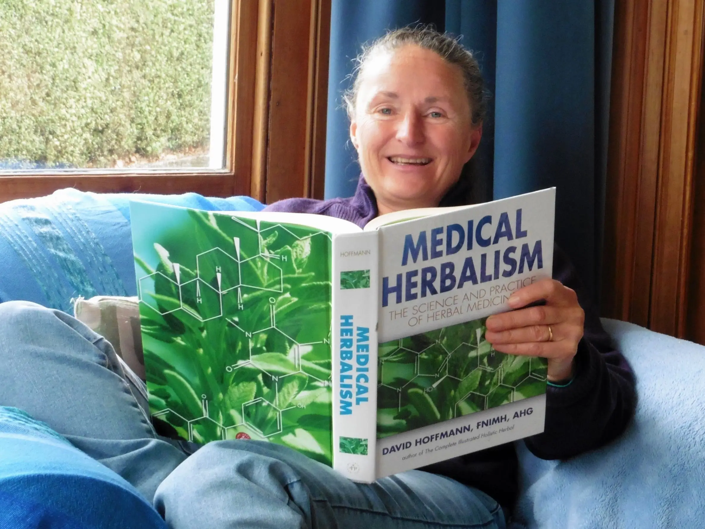 The author's partner reading a book called 'Medical Herbalism'