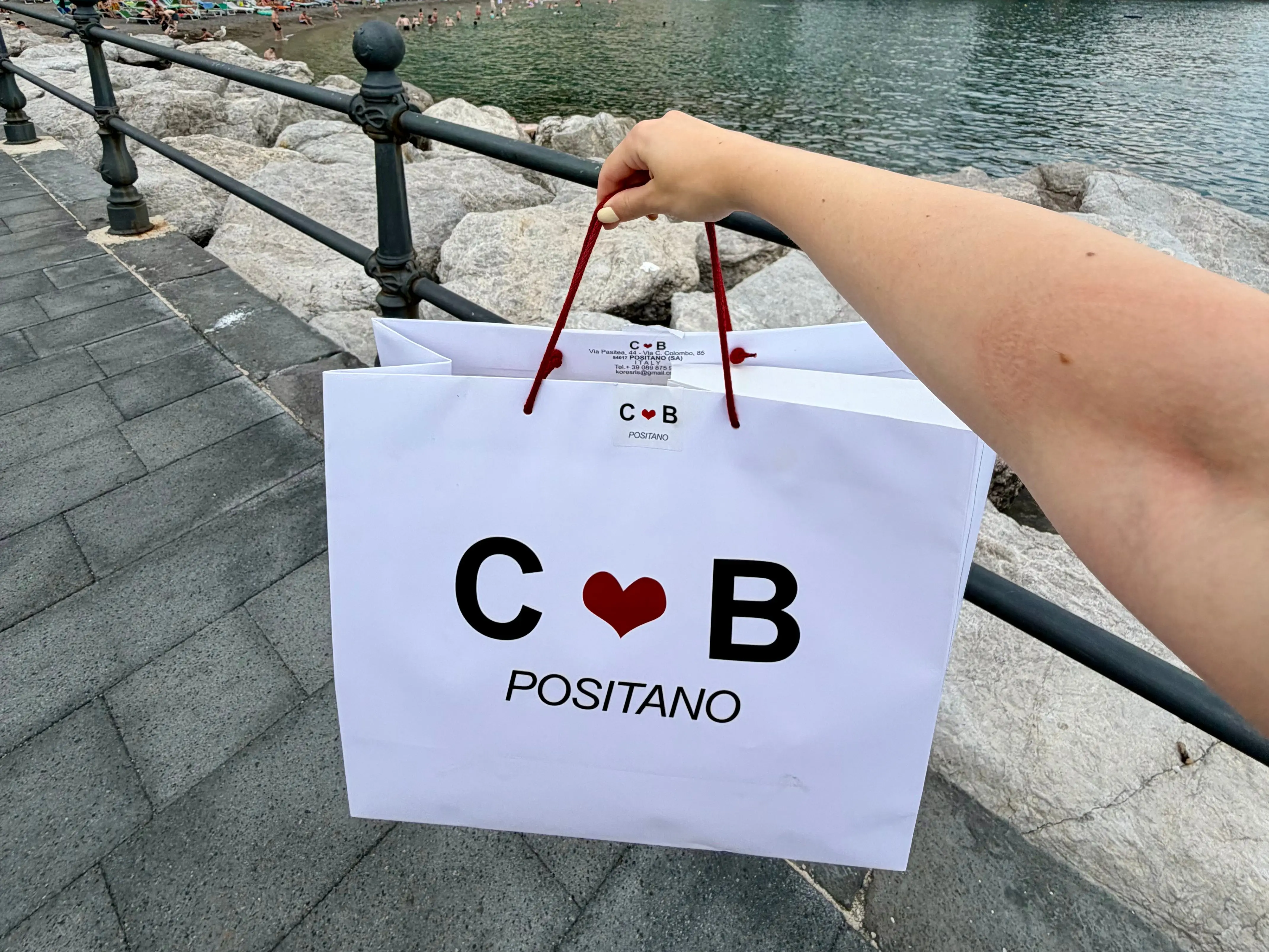 Woman holding C heart B bag in Positano