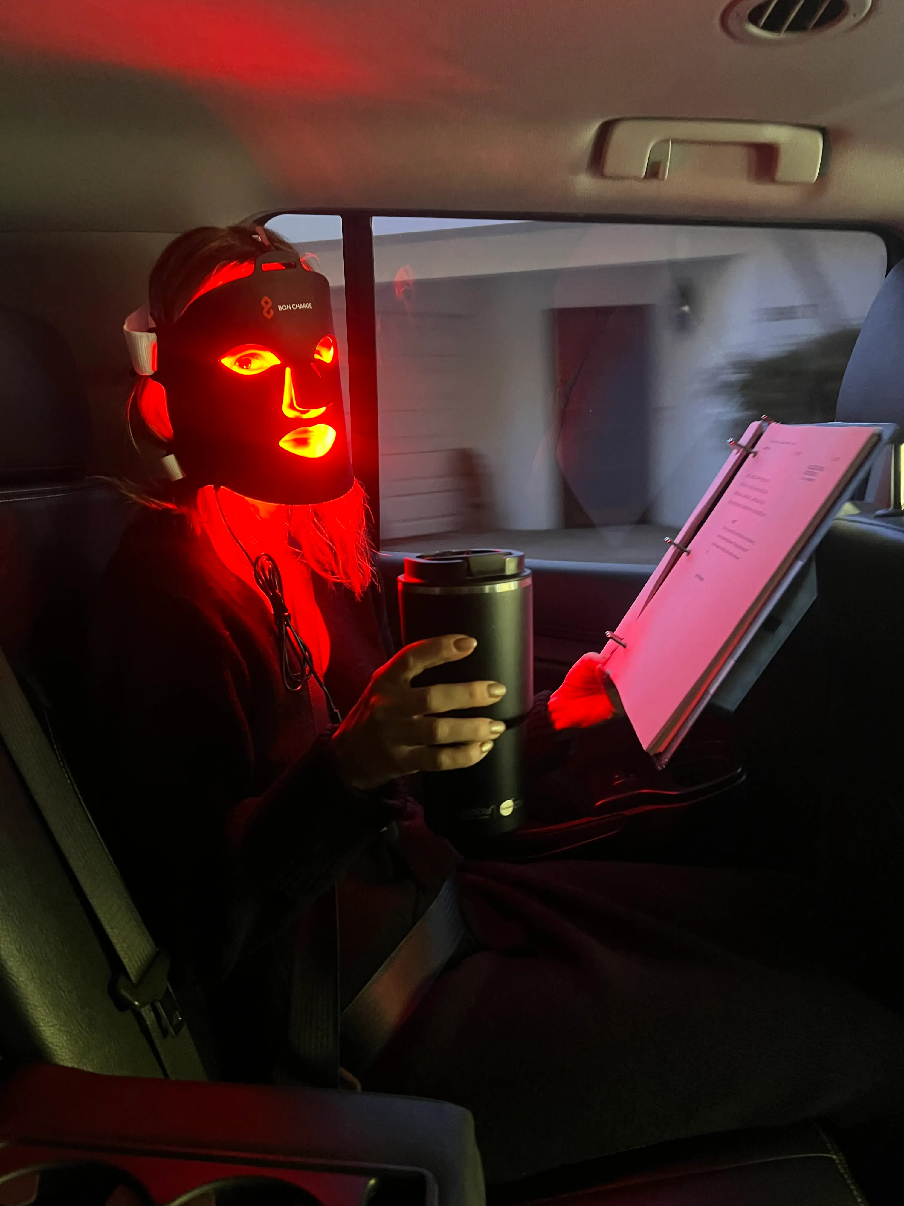 Keltie Knight in a red light mask in a car