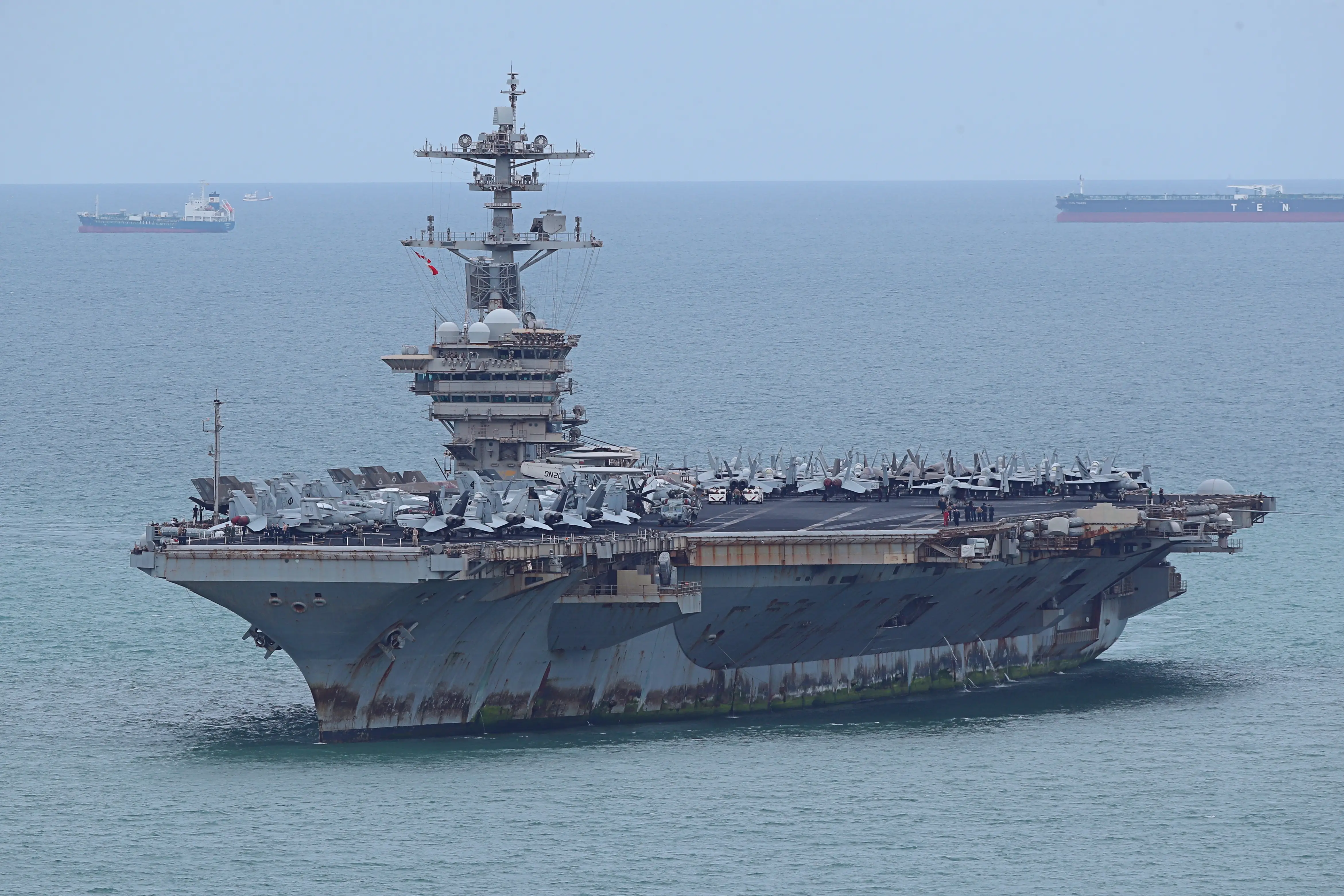 US Navy USS Abraham Lincoln aircraft carrier sails in blue water upon arrival to Thailand.