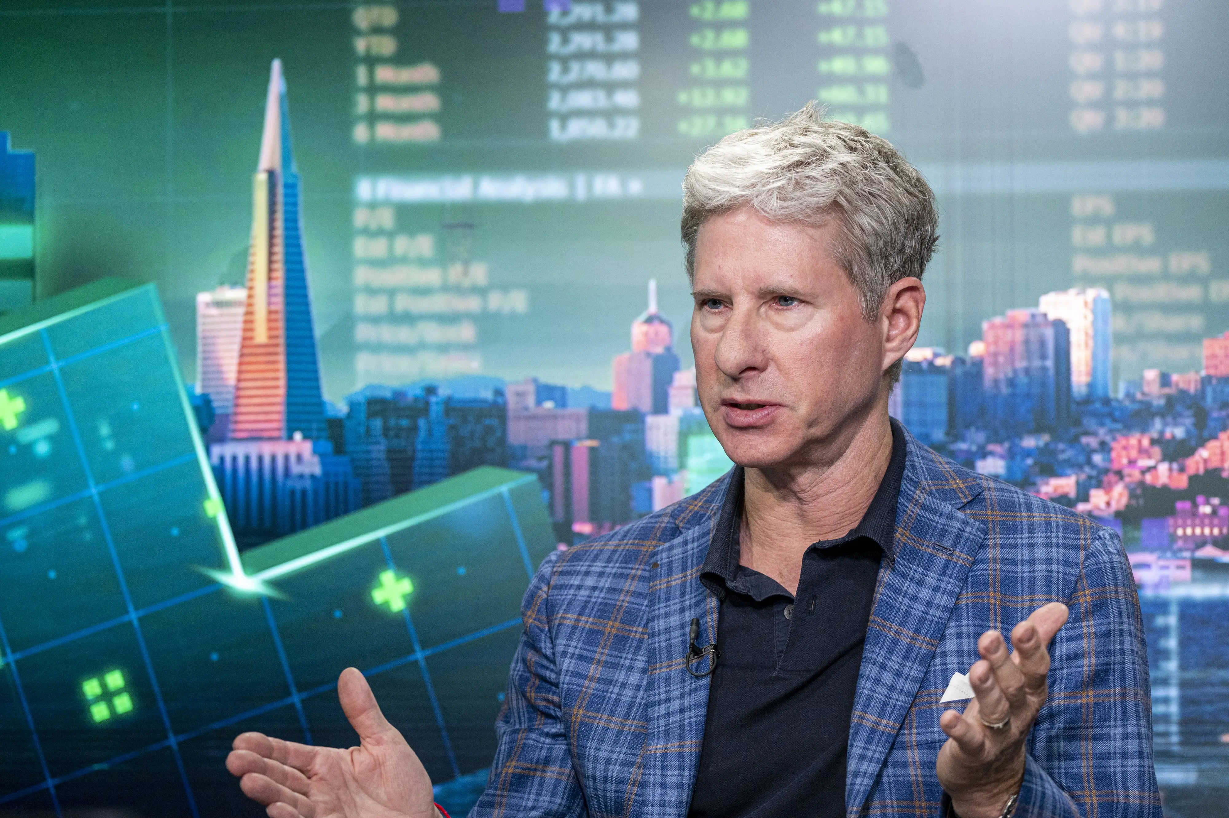 Chris Larsen, the cofounder of Ripple, talks in front of a digital graphic wall