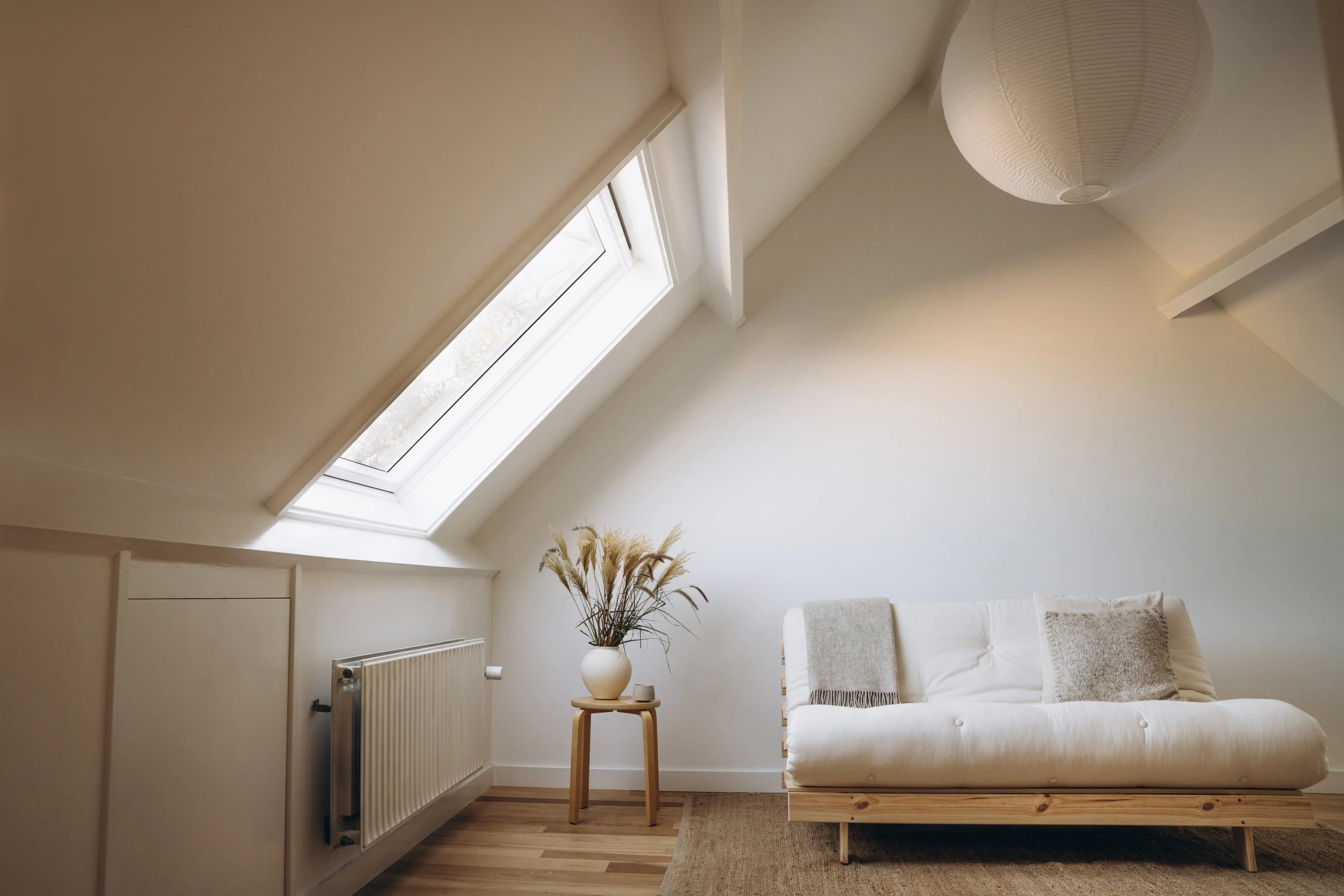 Room with angled wall with window, white ceiling and paper lantern