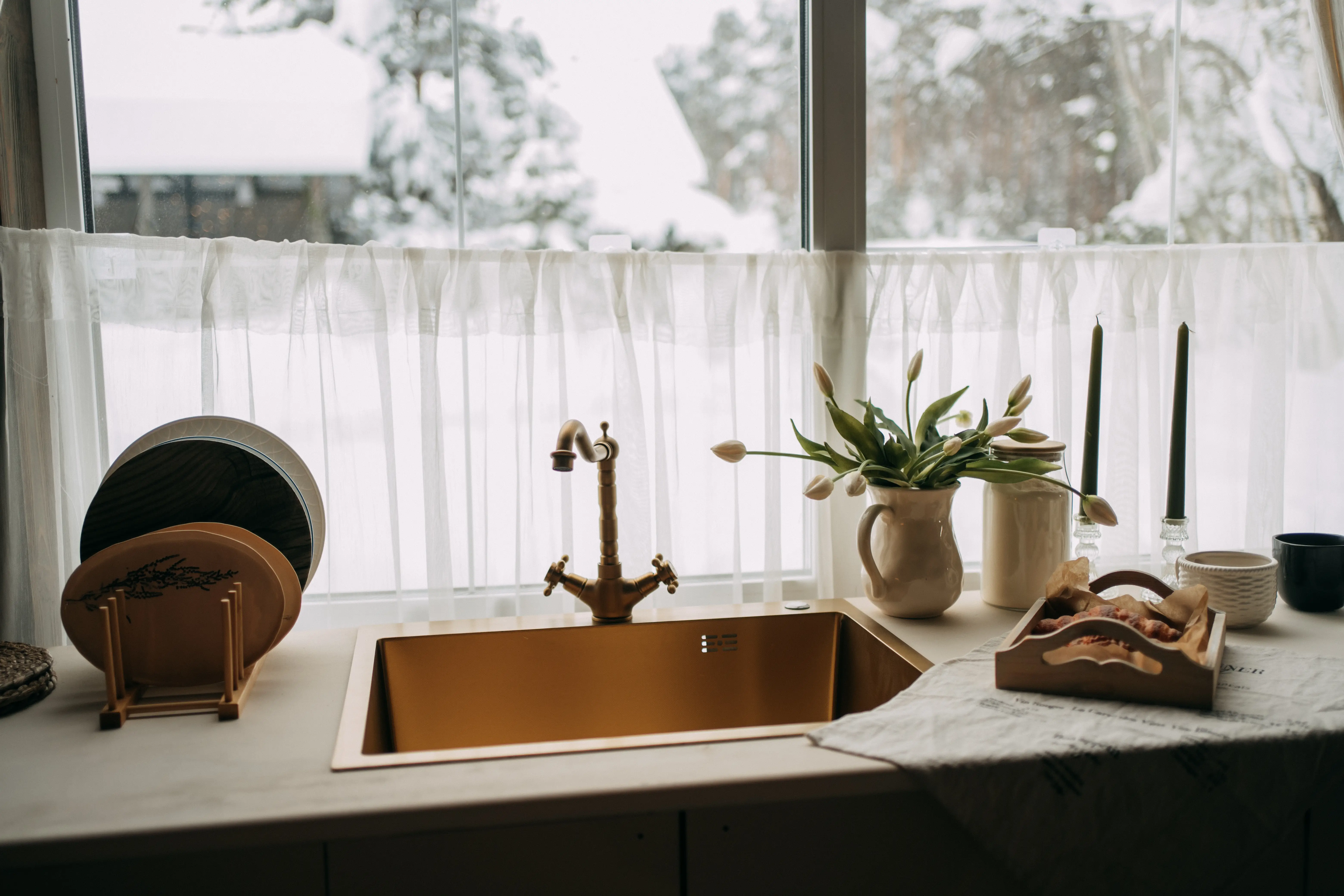 semi-sheer white curtain blocking part of window behind sink