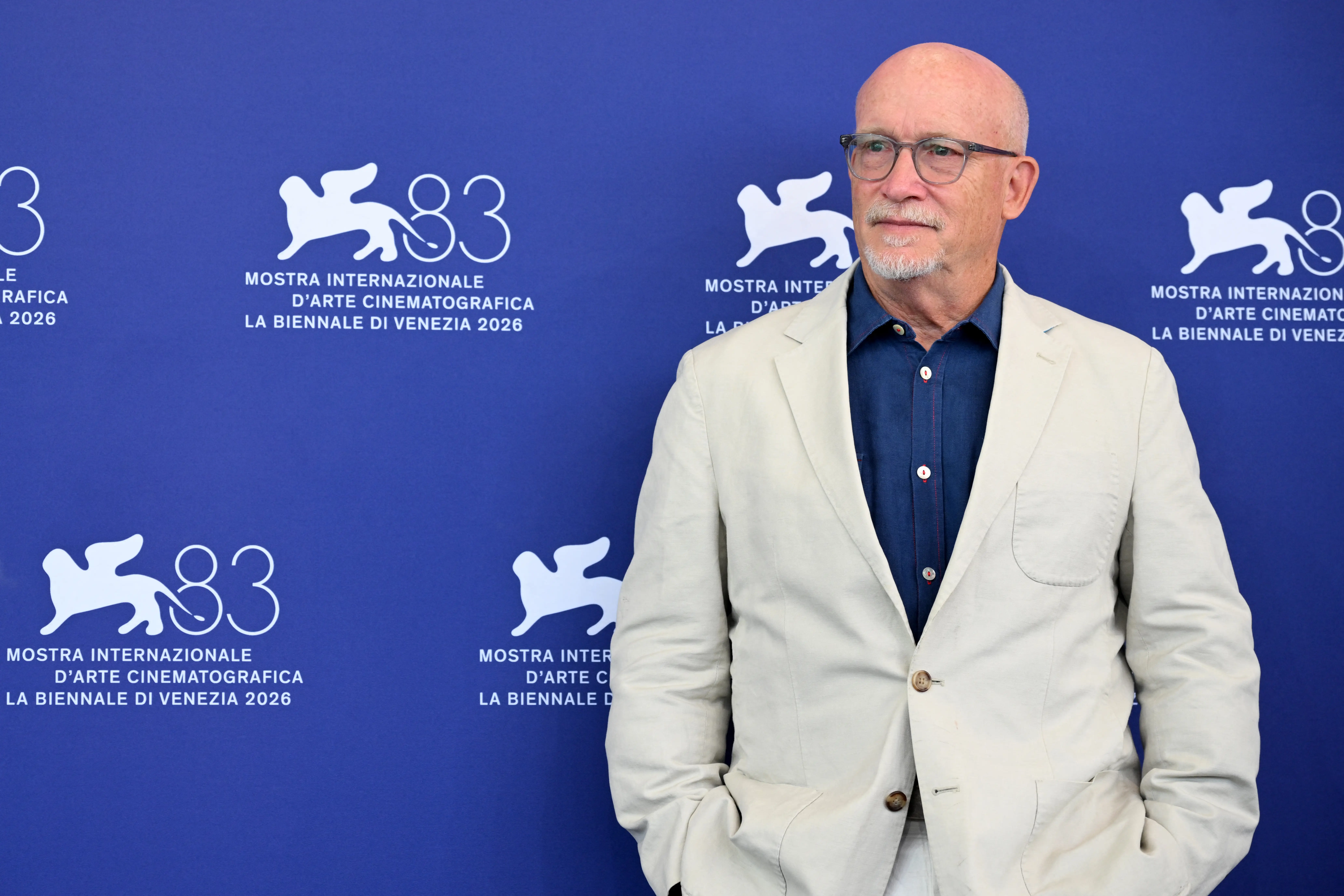 Alex Gibney in a cream jacket and blue shirt