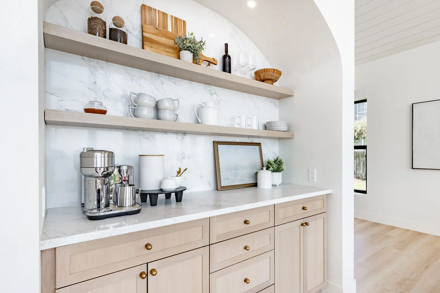 Built-in coffee bar area with light wood cabinets, shelving, drawers