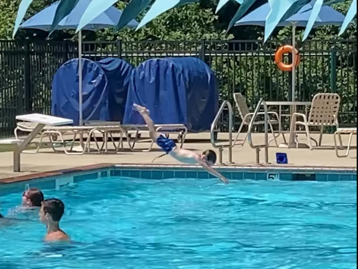 A little boy diving into a swimming pool.
